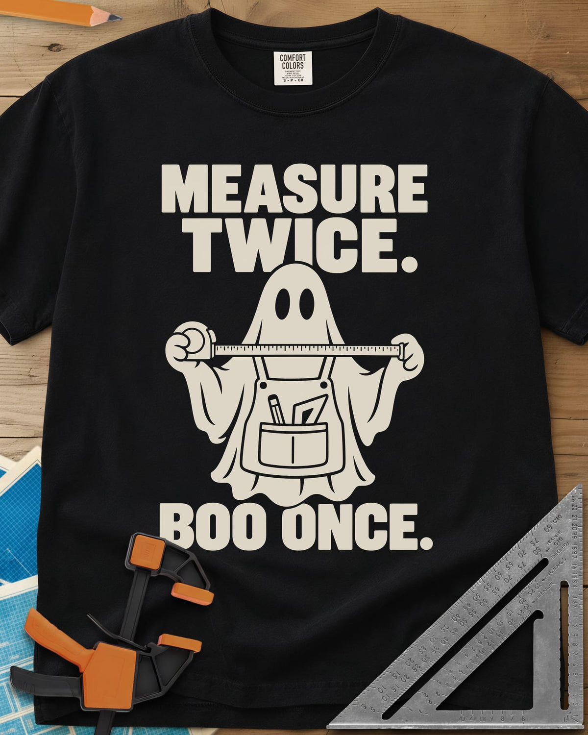 Measure Twice, Boo Once heavyweight tee in Black, a ghost in a tool apron holding a stretched tape measure