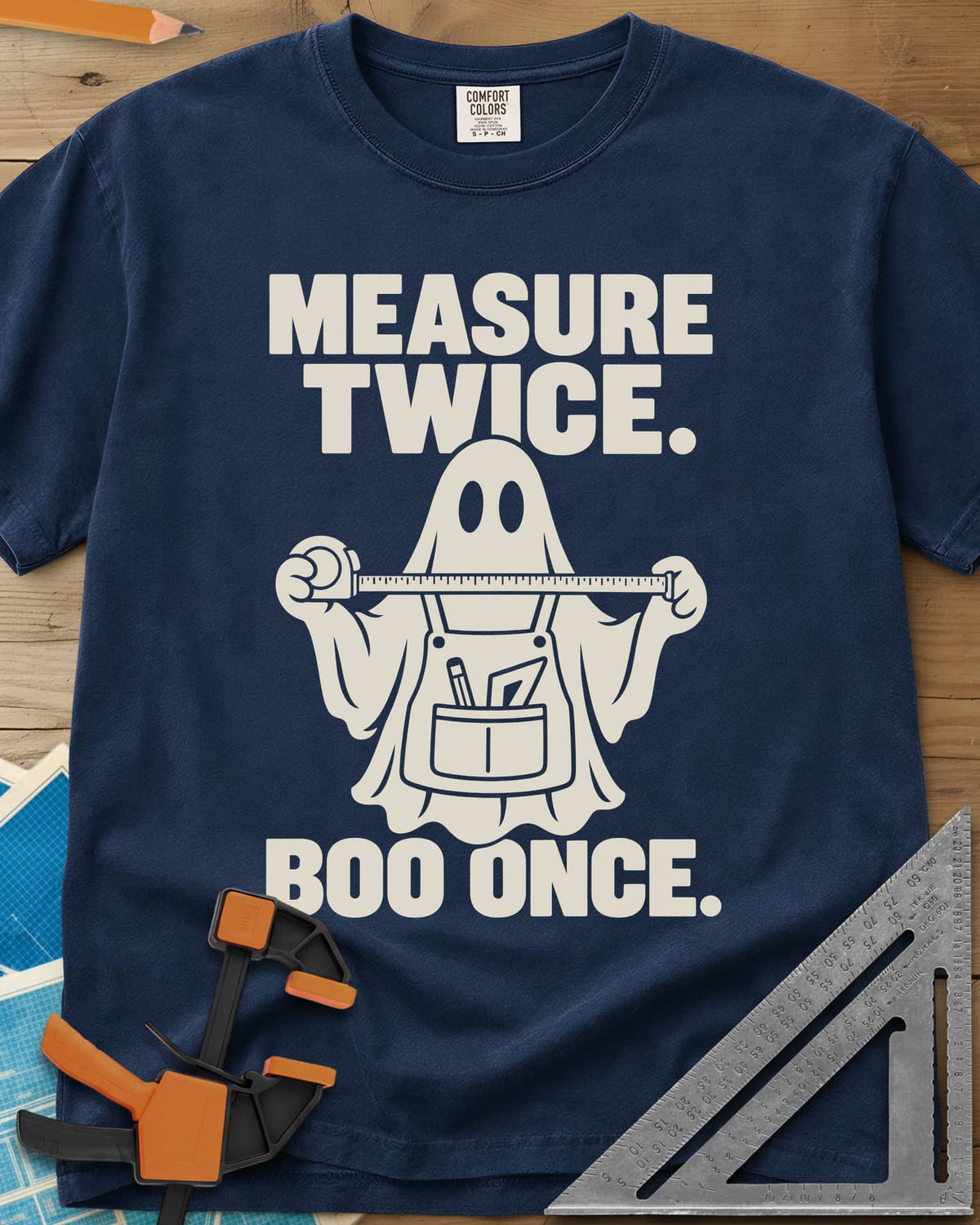 Measure Twice, Boo Once heavyweight tee in Navy, a ghost in a tool apron holding a stretched tape measure
