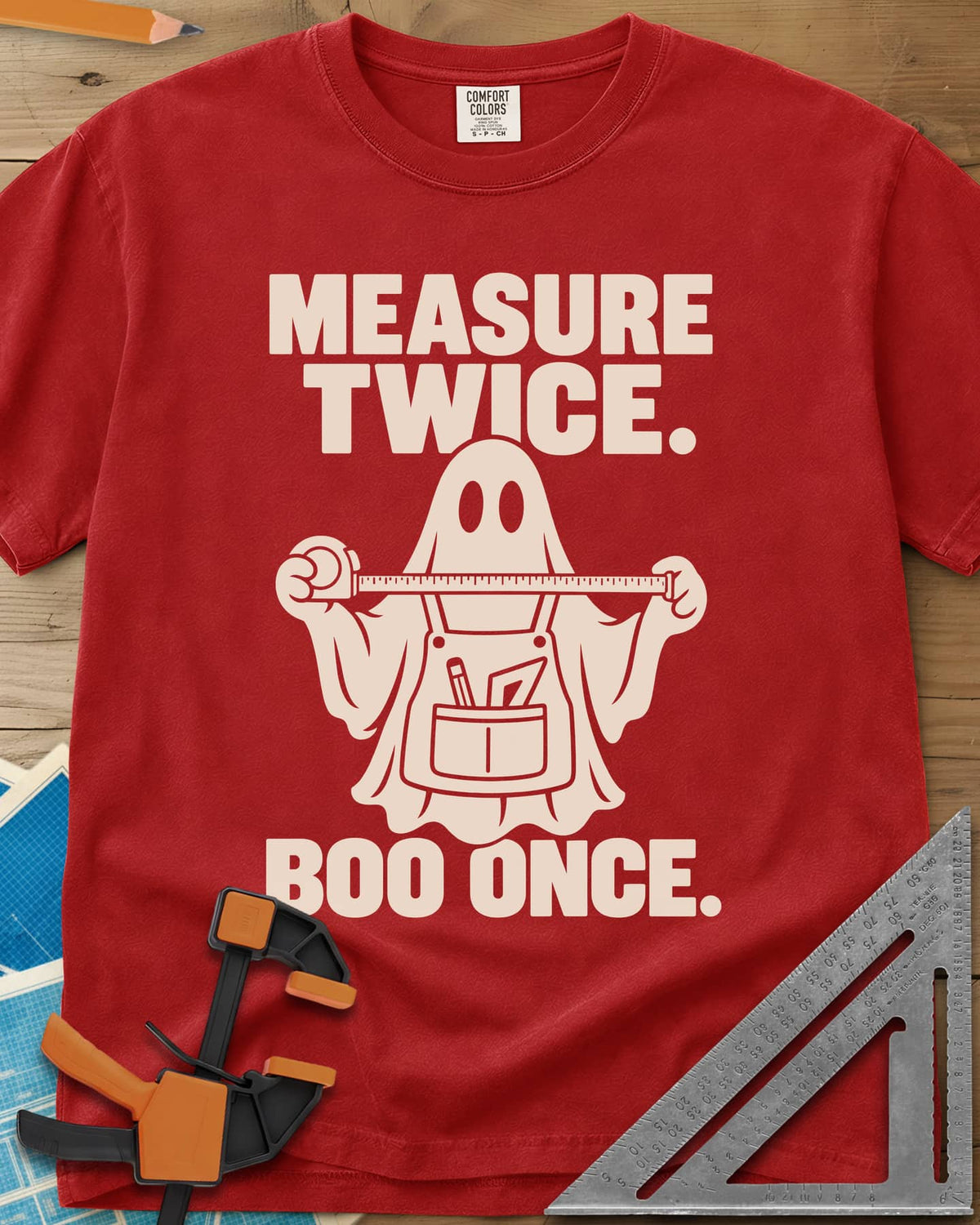Measure Twice, Boo Once heavyweight tee in Red, a ghost in a tool apron holding a stretched tape measure