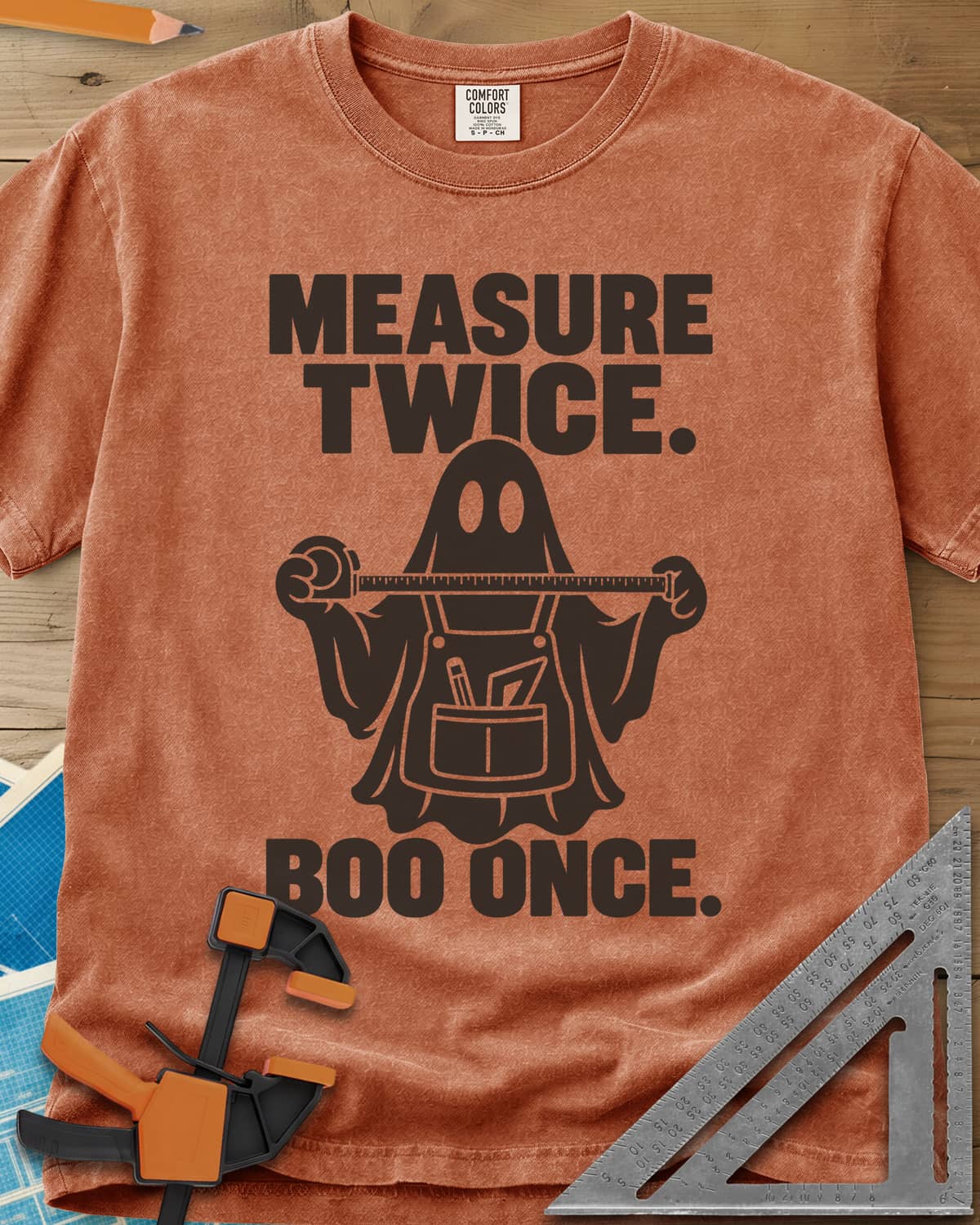 Measure Twice, Boo Once heavyweight tee in Yam, a ghost in a tool apron holding a stretched tape measure