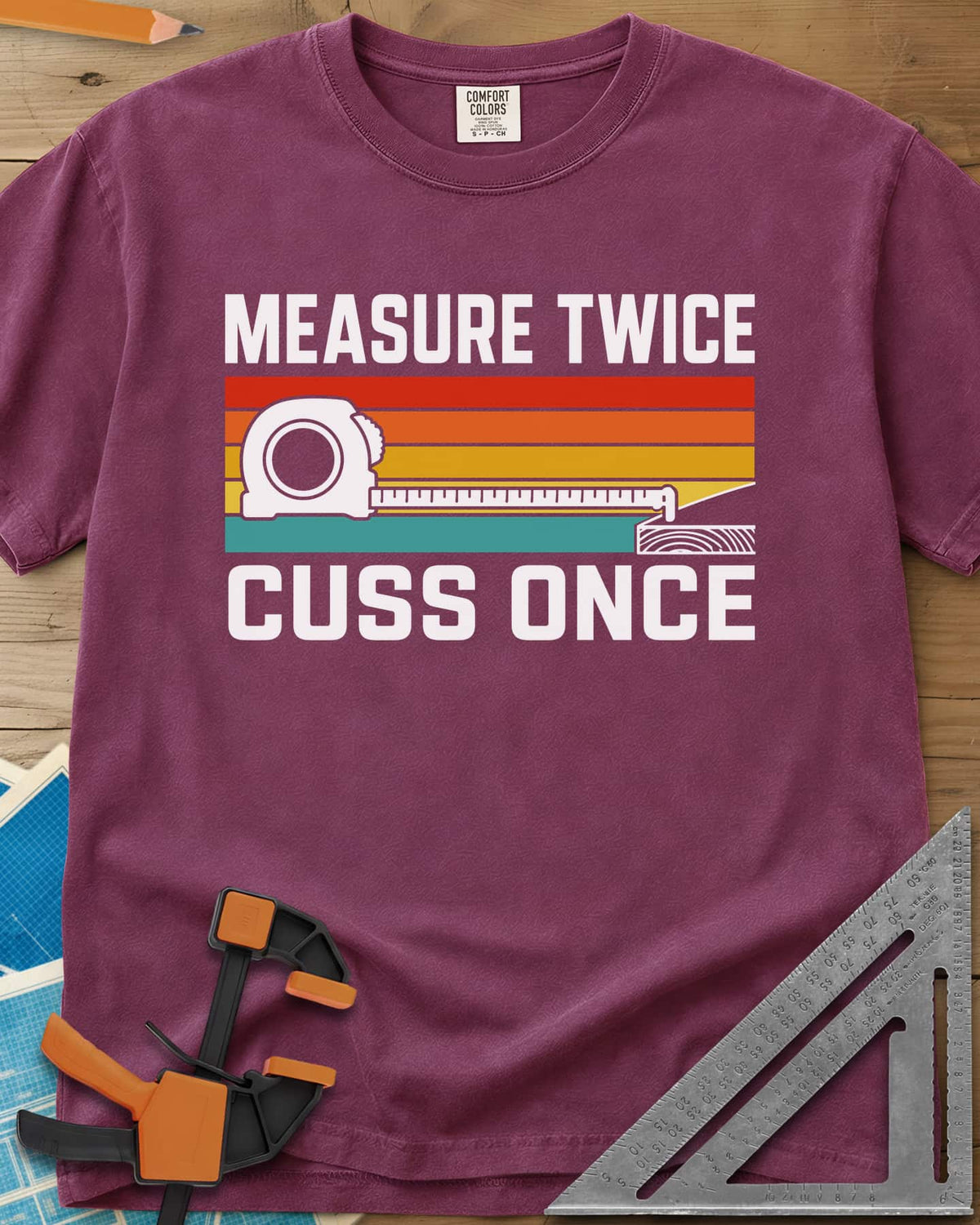 Measure Twice Cuss Once heavyweight tee in Berry, a white tape measure across retro red, orange, gold and teal stripes
