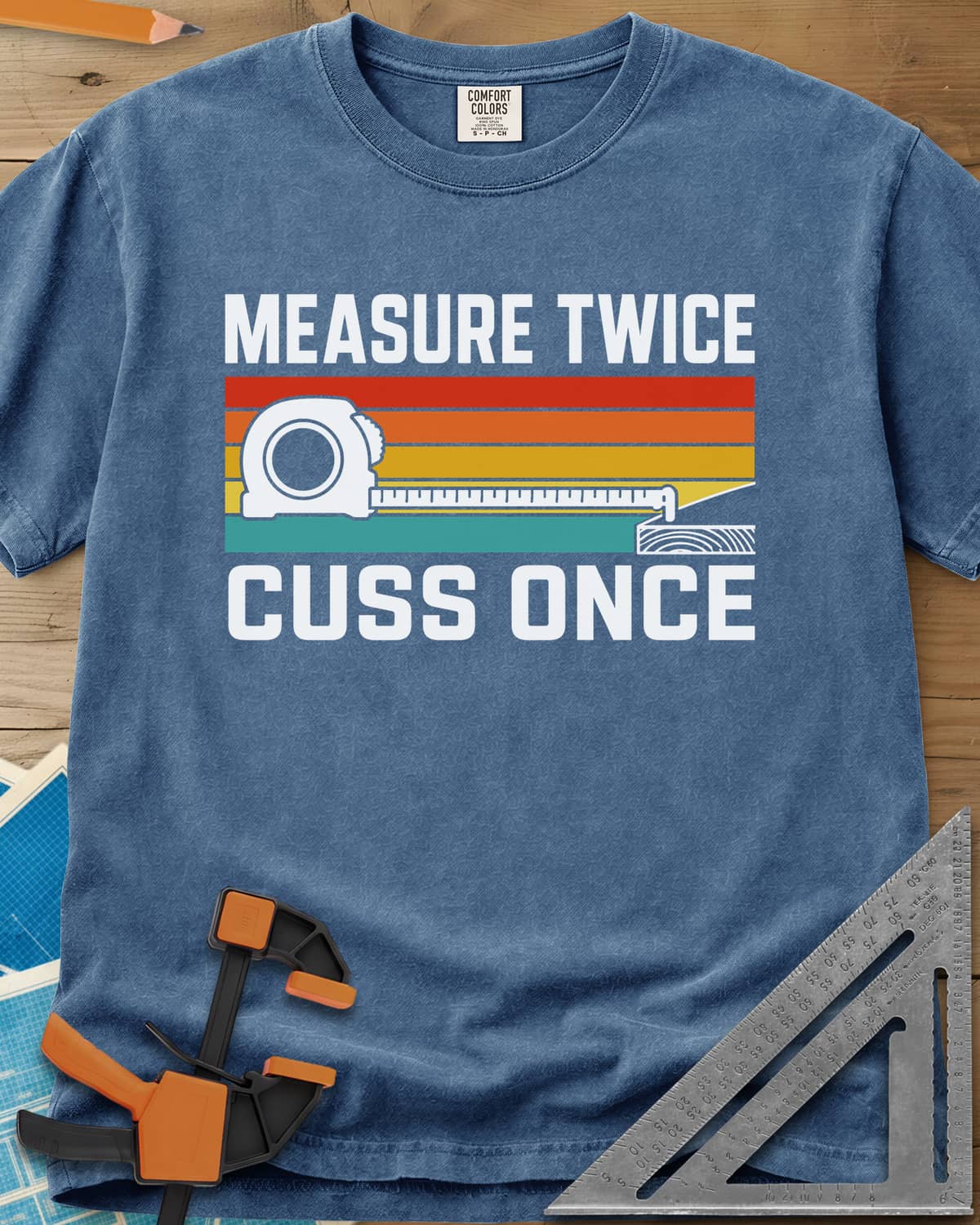 Measure Twice Cuss Once heavyweight tee in Blue Jean, a white tape measure across retro red, orange, gold and teal stripes