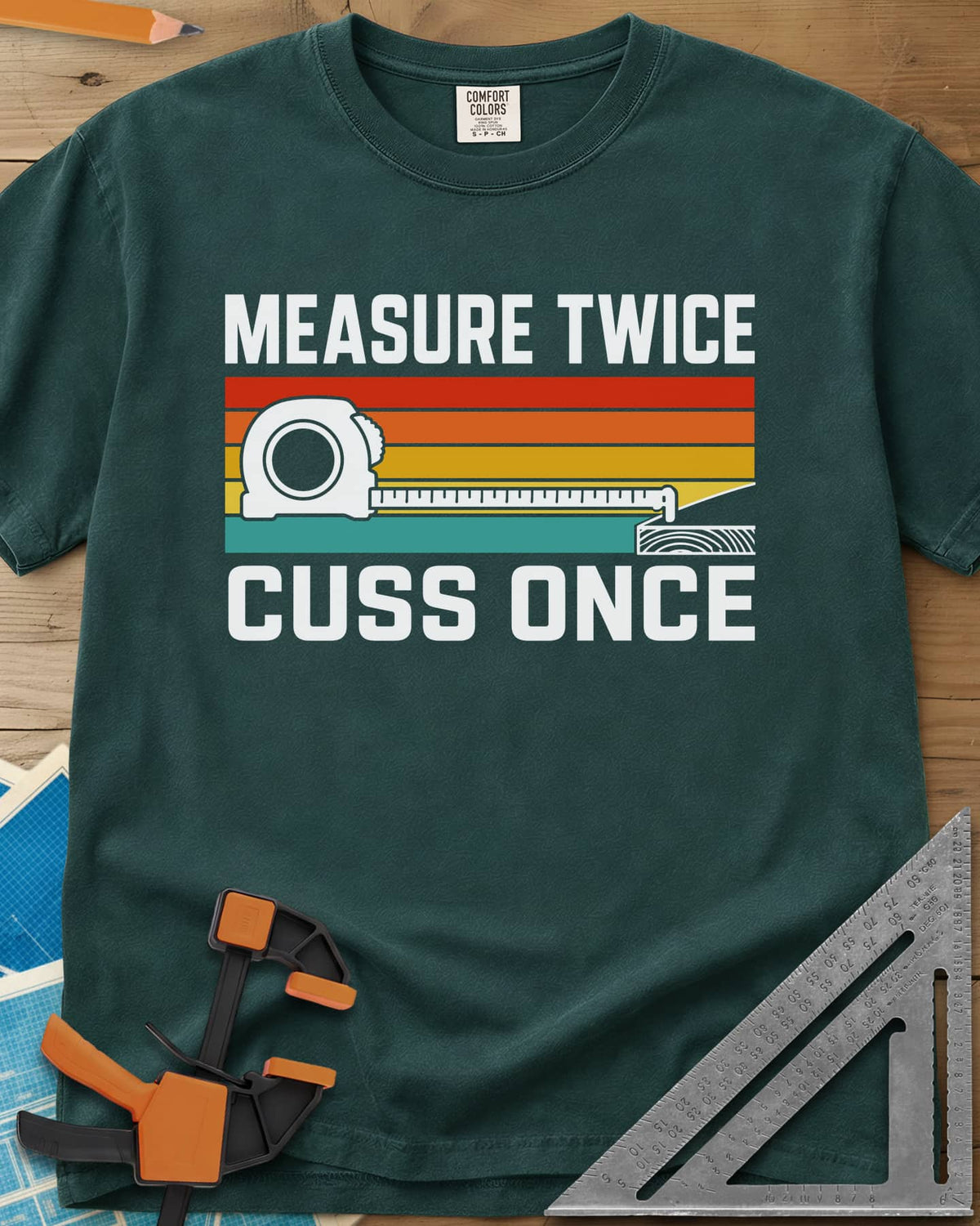 Measure Twice Cuss Once heavyweight tee in Blue Spruce, a white tape measure across retro red, orange, gold and teal stripes