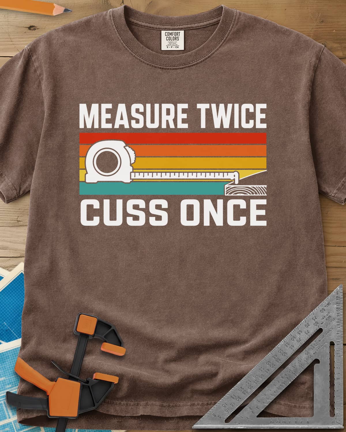 Measure Twice Cuss Once heavyweight tee in Espresso, a white tape measure across retro red, orange, gold and teal stripes