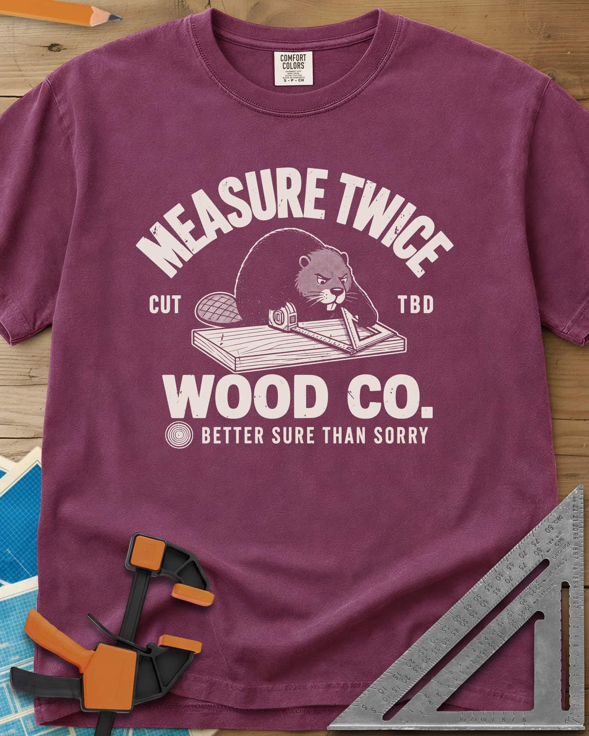 Measure Twice heavyweight tee in Berry, a determined beaver measuring a board in a Wood Co. badge