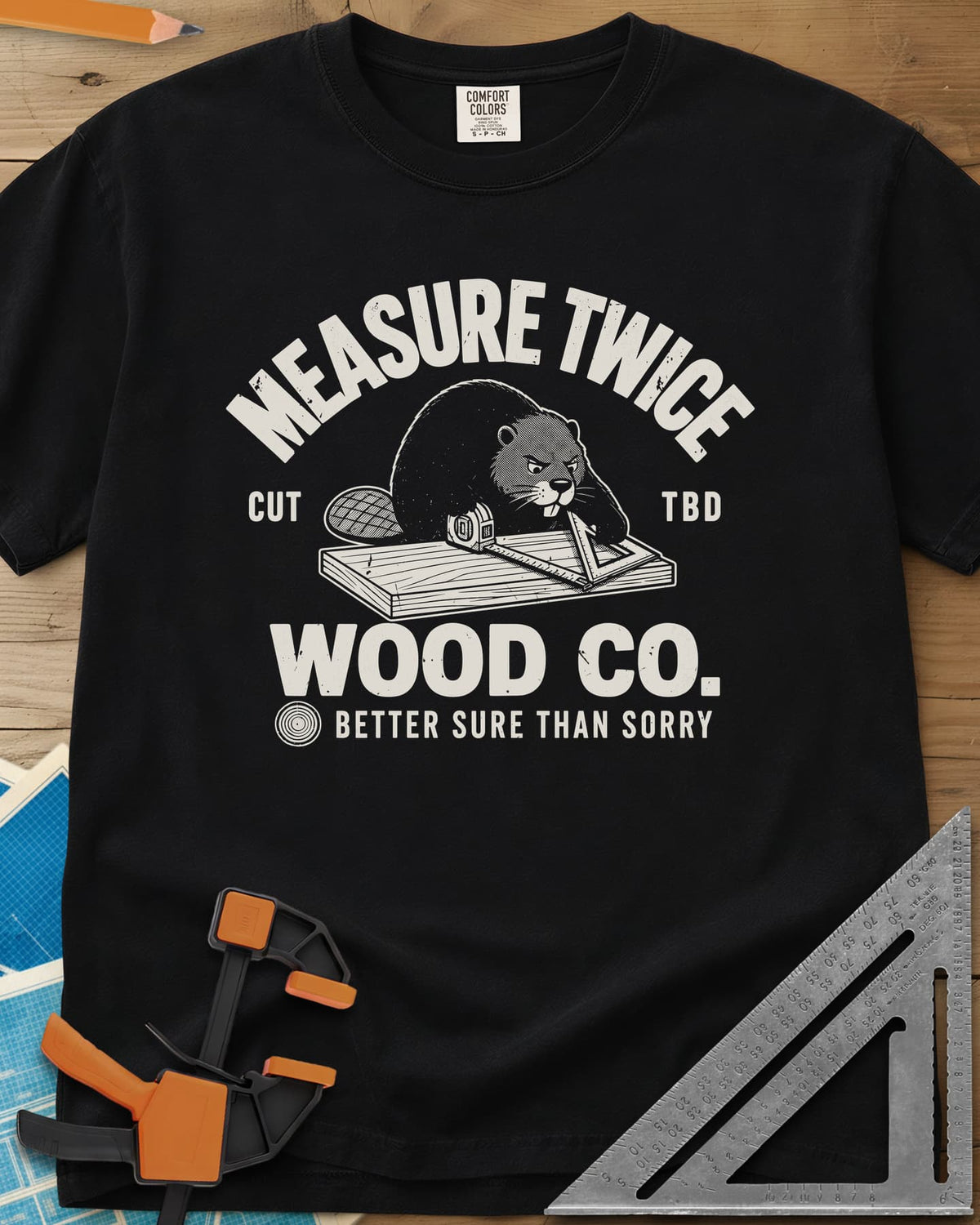 Measure Twice heavyweight tee in Black, a determined beaver measuring a board in a Wood Co. badge