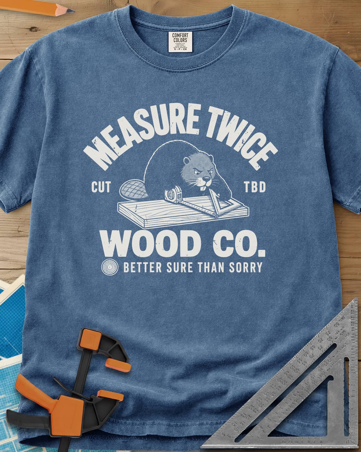 Measure Twice heavyweight tee in Blue Jean, a determined beaver measuring a board in a Wood Co. badge