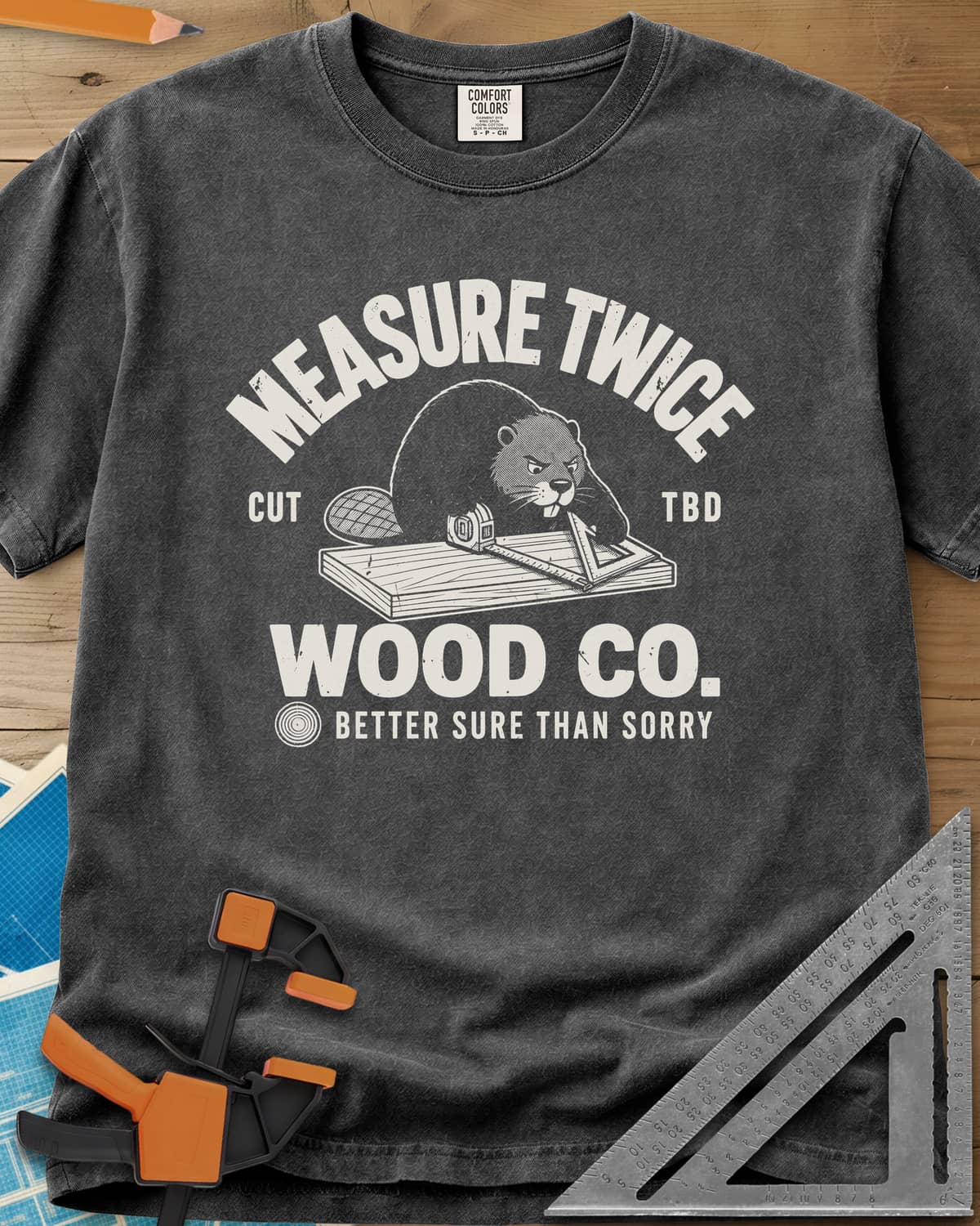 Measure Twice heavyweight tee in Pepper, a determined beaver measuring a board in a Wood Co. badge