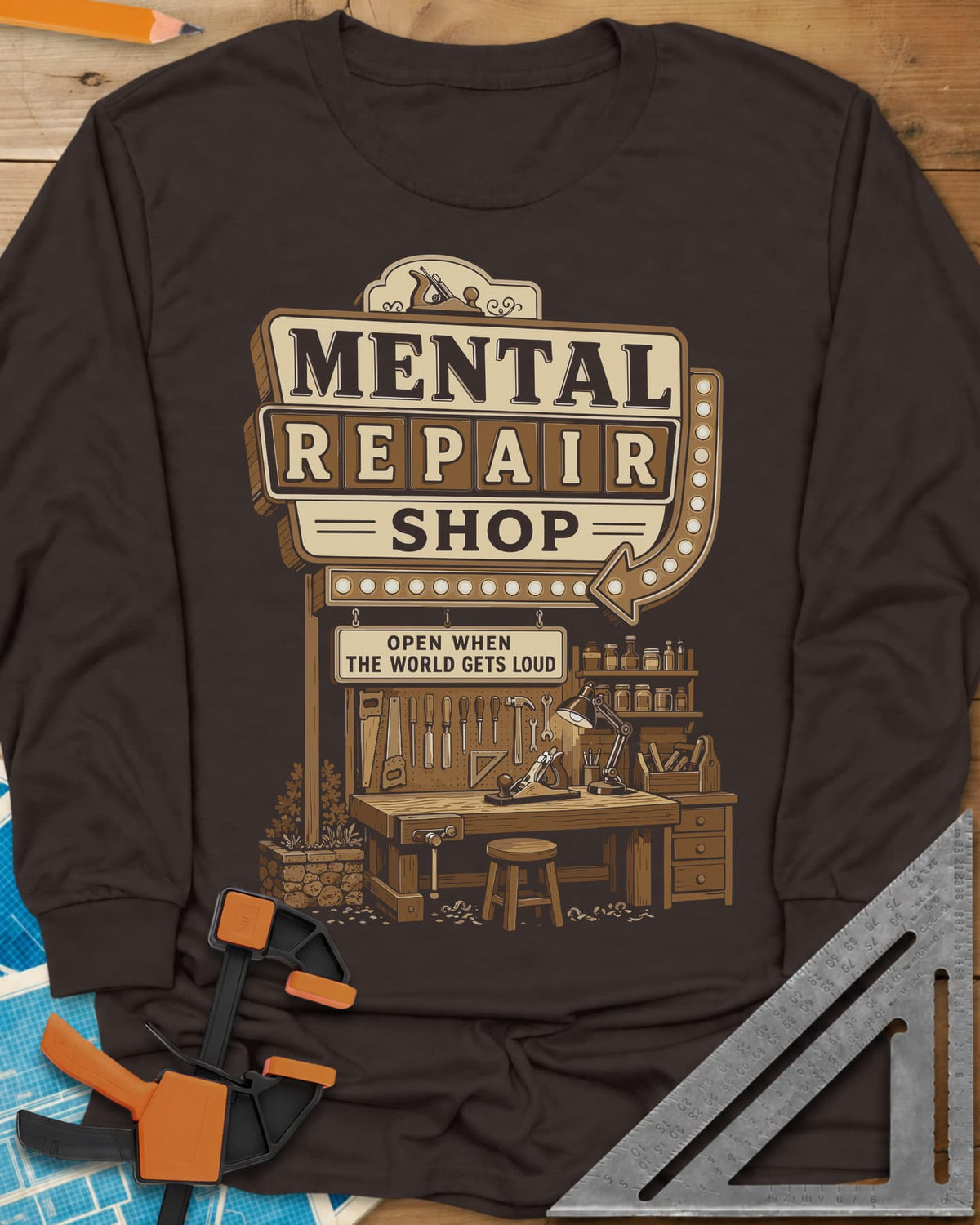 Mental Repair Shop long sleeve shirt in Dark Chocolate, a retro roadside sign over a tidy woodworking bench and pegboard
