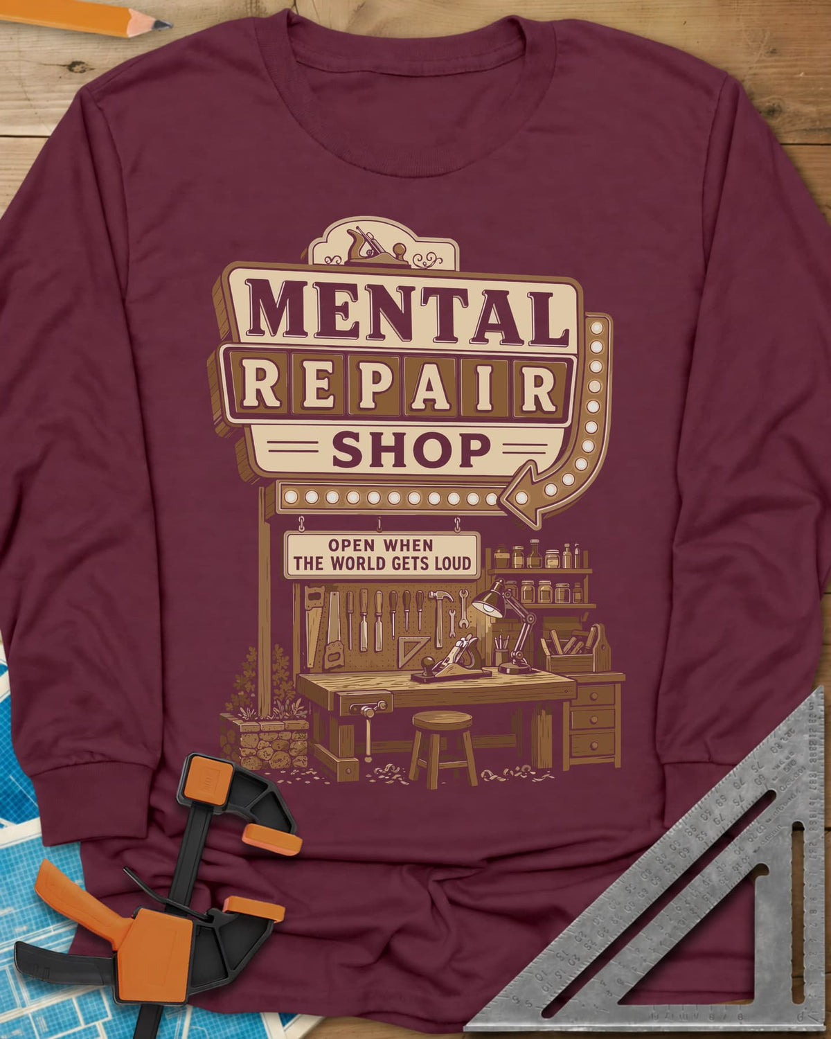 Mental Repair Shop long sleeve shirt in Maroon, a retro roadside sign over a tidy woodworking bench and pegboard