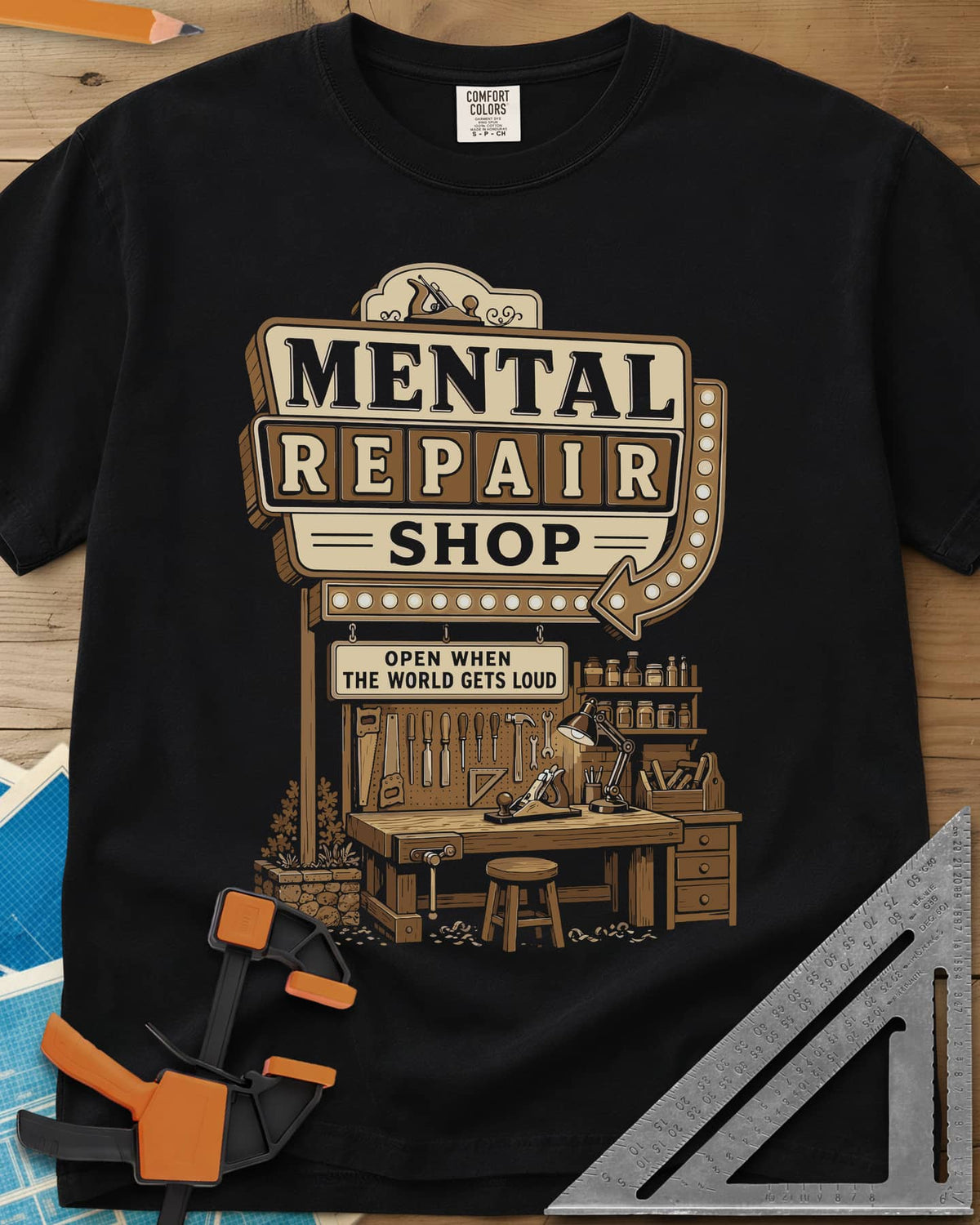 Mental Repair Shop heavyweight tee in Black, a retro roadside sign over a tidy woodworking bench and pegboard