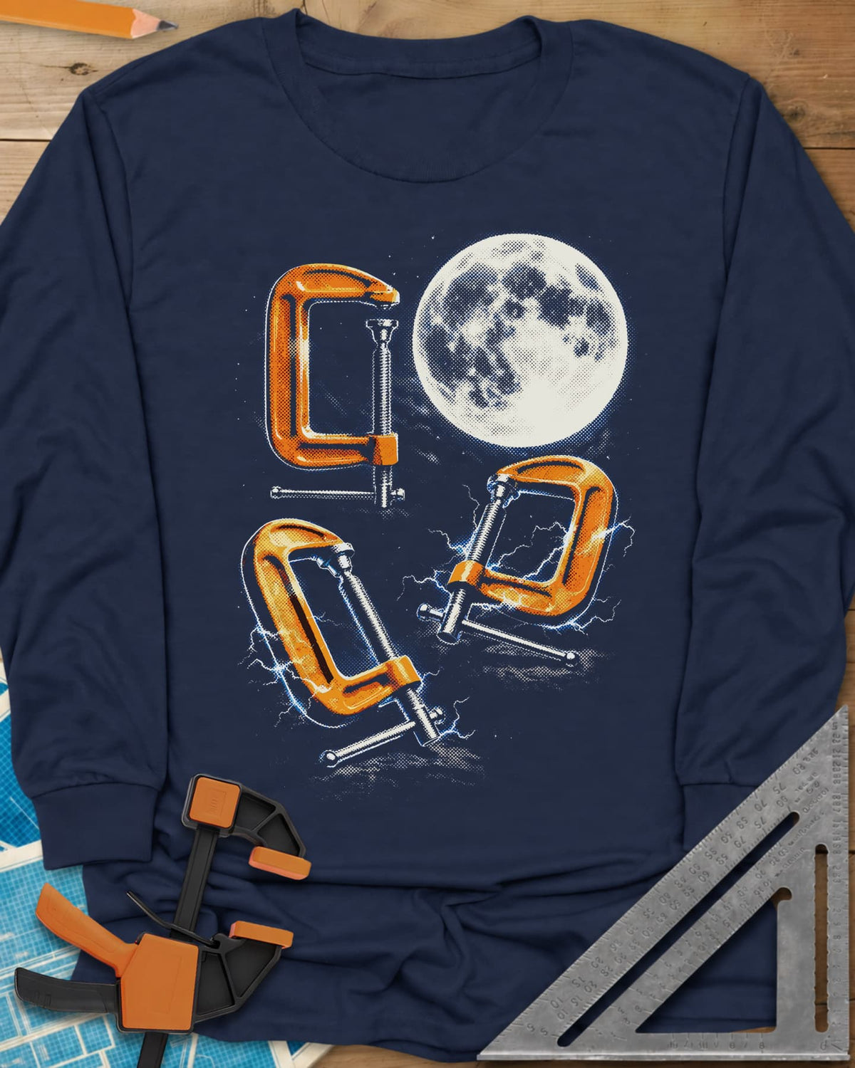 Midnight Clamp Trio long sleeve shirt in Navy, three orange C-clamps under a full moon with blue sparks