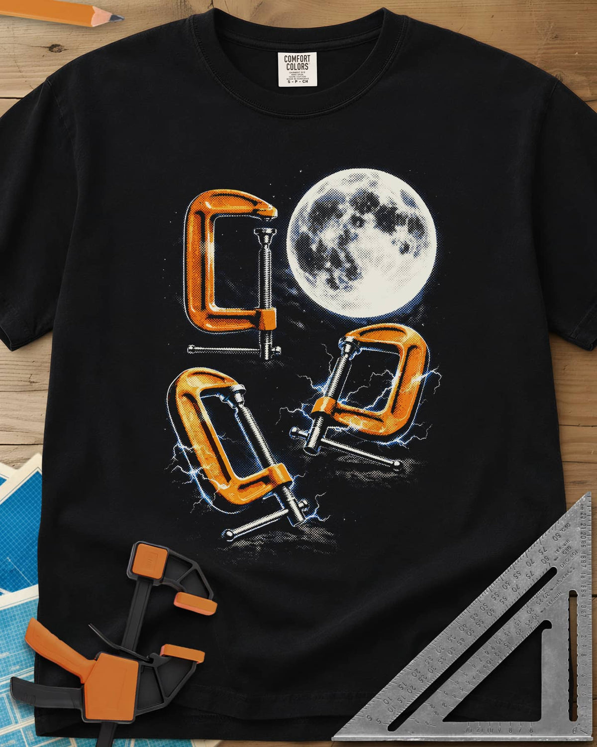 Midnight Clamp Trio heavyweight tee in Black, three orange C-clamps under a full moon with blue sparks