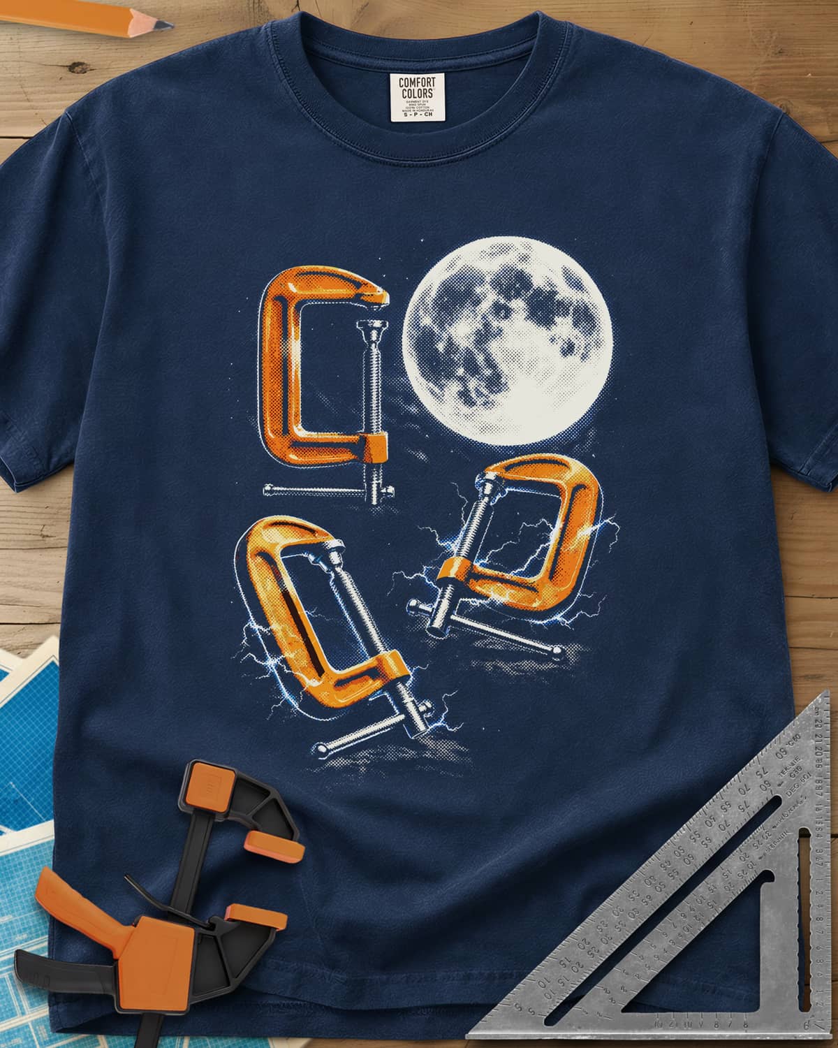 Midnight Clamp Trio heavyweight tee in Navy, three orange C-clamps under a full moon with blue sparks