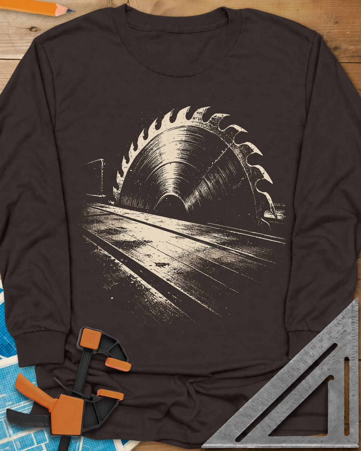 Midnight Table Saw long sleeve shirt in Dark Chocolate, a grainy cream saw blade rising over a long table, no words
