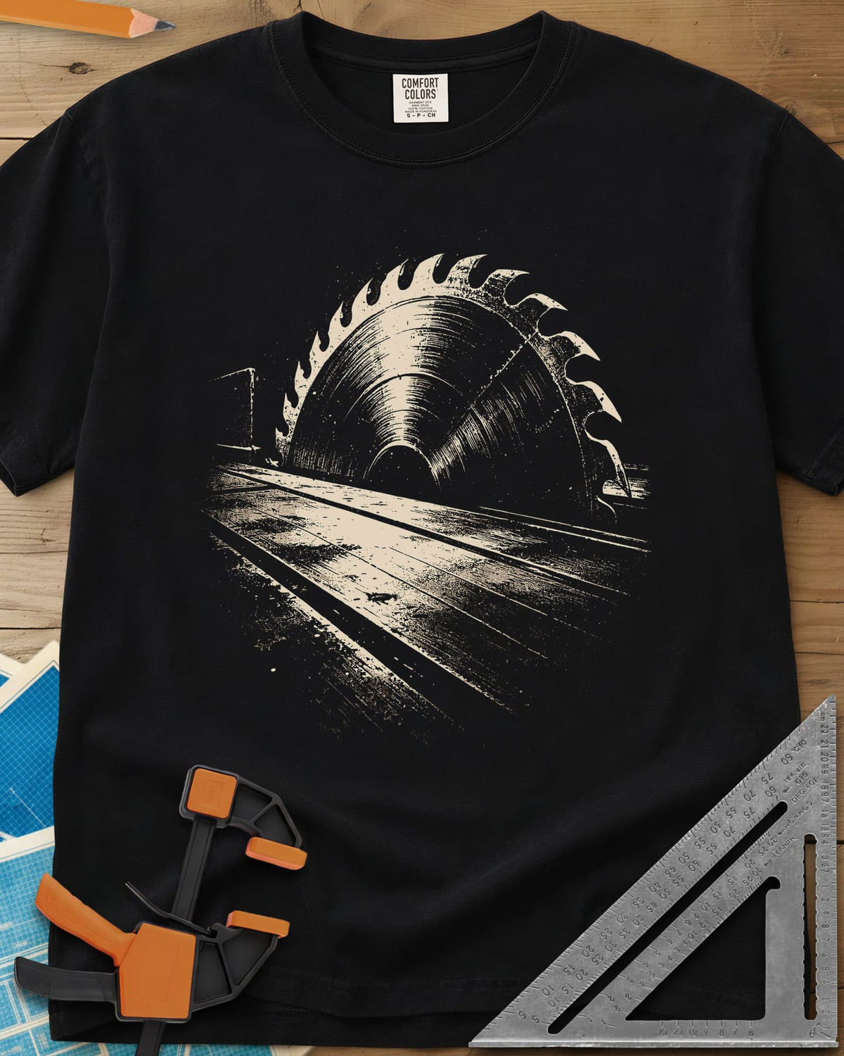 Midnight Table Saw heavyweight tee in Black, a grainy cream saw blade rising over a long table, no words