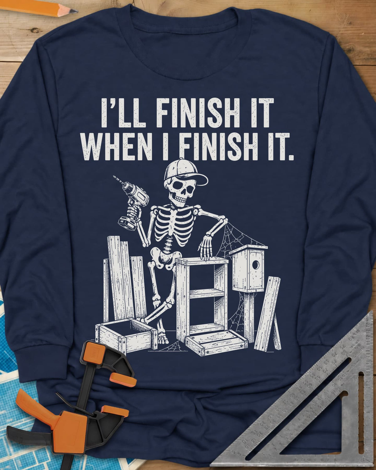 Misses Me At Work long sleeve shirt in Navy, a skeleton in a ball cap with a drill among half-built projects