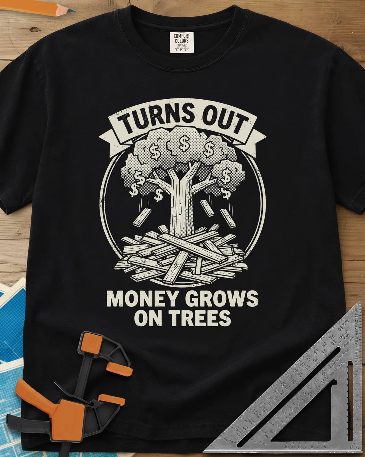 Money Grows On Trees heavyweight tee in Black, a round emblem of a tree with dollar-sign leaves above a lumber pile