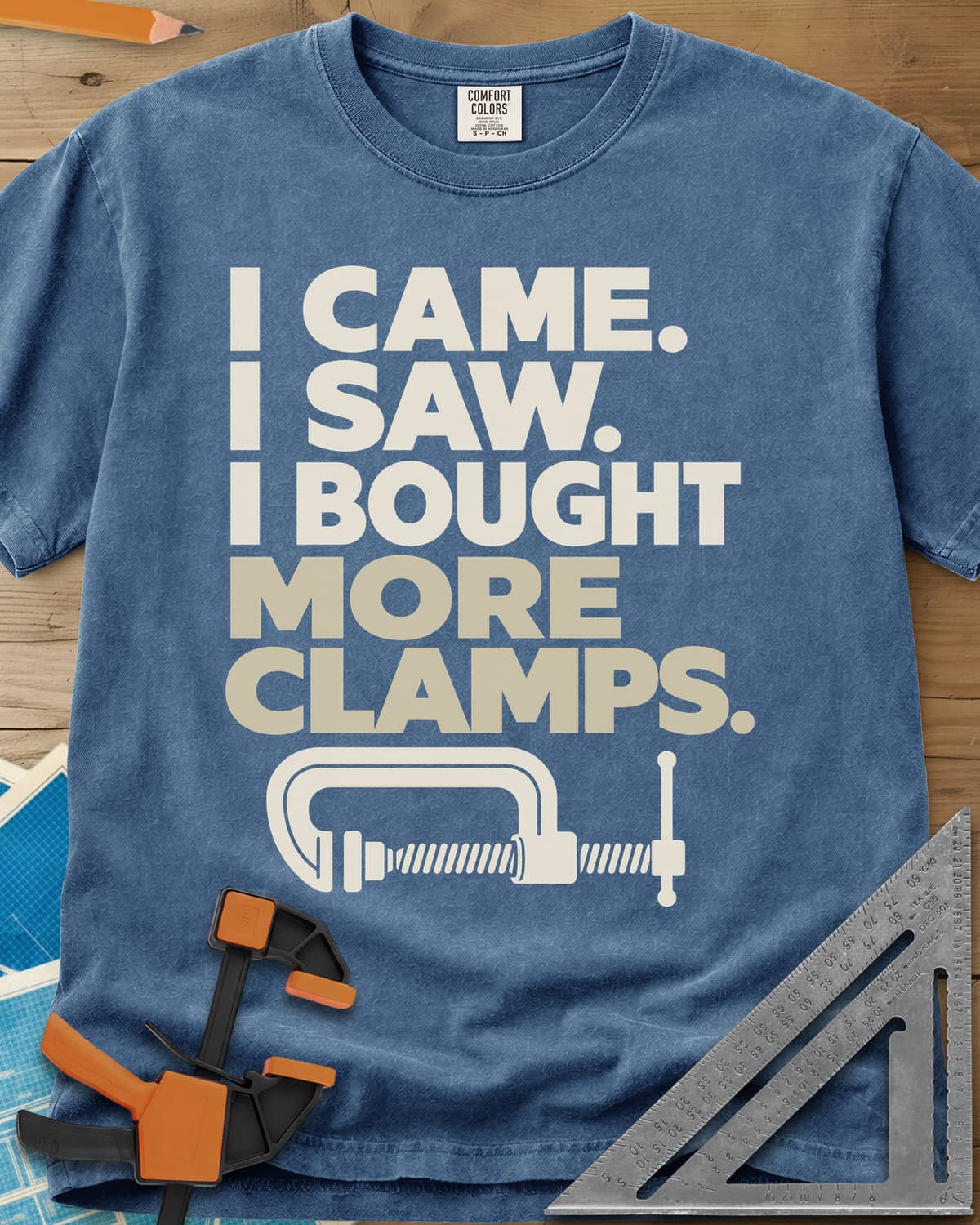 More Clamps heavyweight tee in Blue Jean, four lines of block letters with a C-clamp underneath
