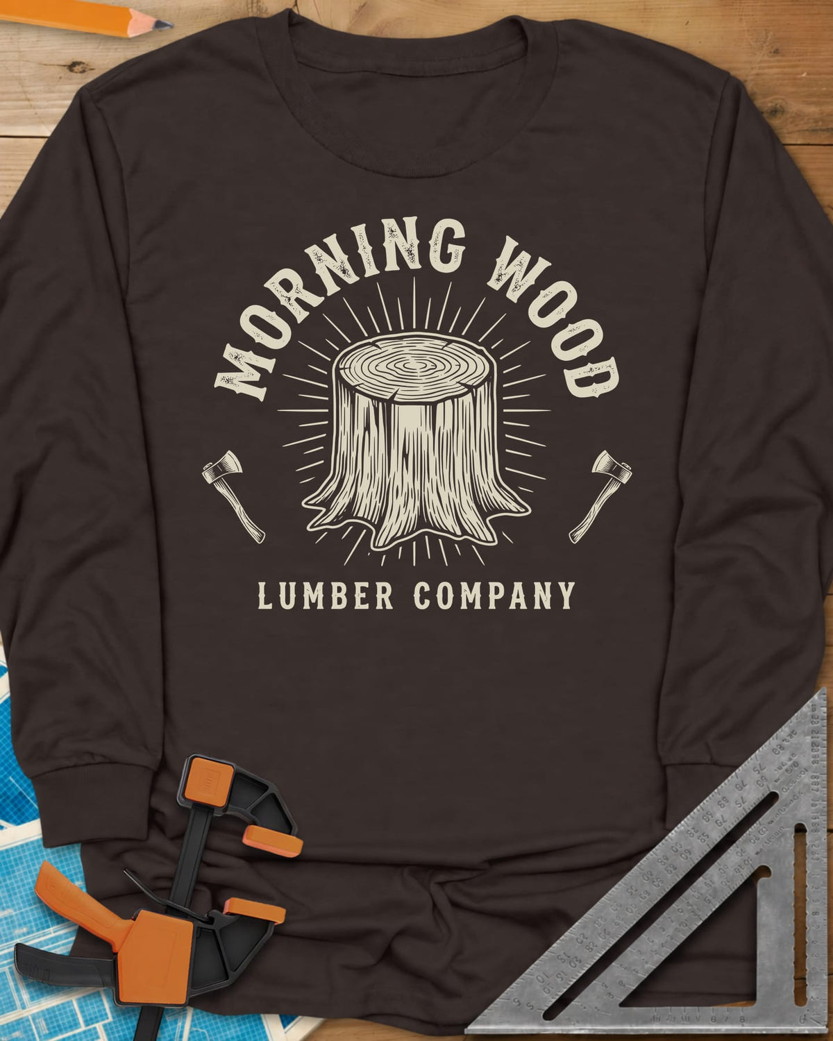 Morning Wood Lumber Company long sleeve shirt in Dark Chocolate, a tree stump with sunburst rays between two axes