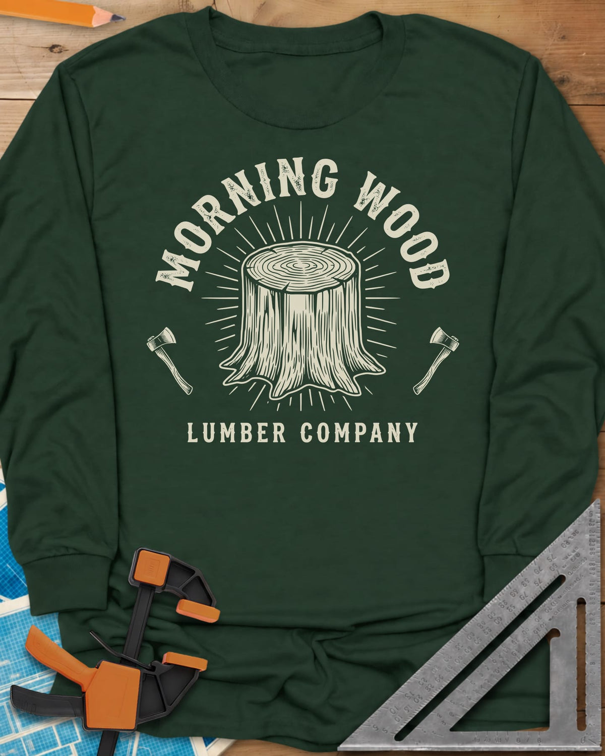 Morning Wood Lumber Company long sleeve shirt in Forest Green, a tree stump with sunburst rays between two axes