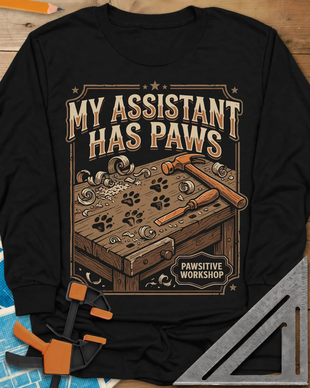 My Assistant Has Paws long sleeve shirt in Black, workbench with paw prints, shavings, a hammer and a chisel