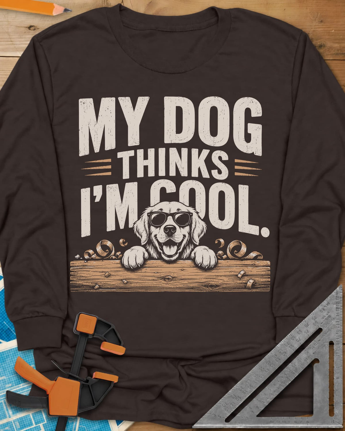 My Dog Thinks I’m Cool long sleeve shirt in Dark Chocolate, a golden retriever in sunglasses peeking over a wood plank