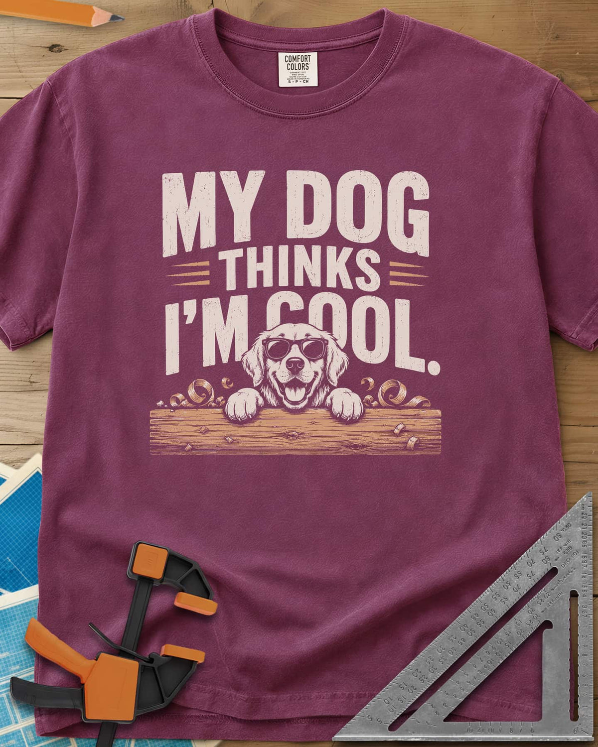 My Dog Thinks I’m Cool heavyweight tee in Berry, a golden retriever in sunglasses peeking over a wood plank