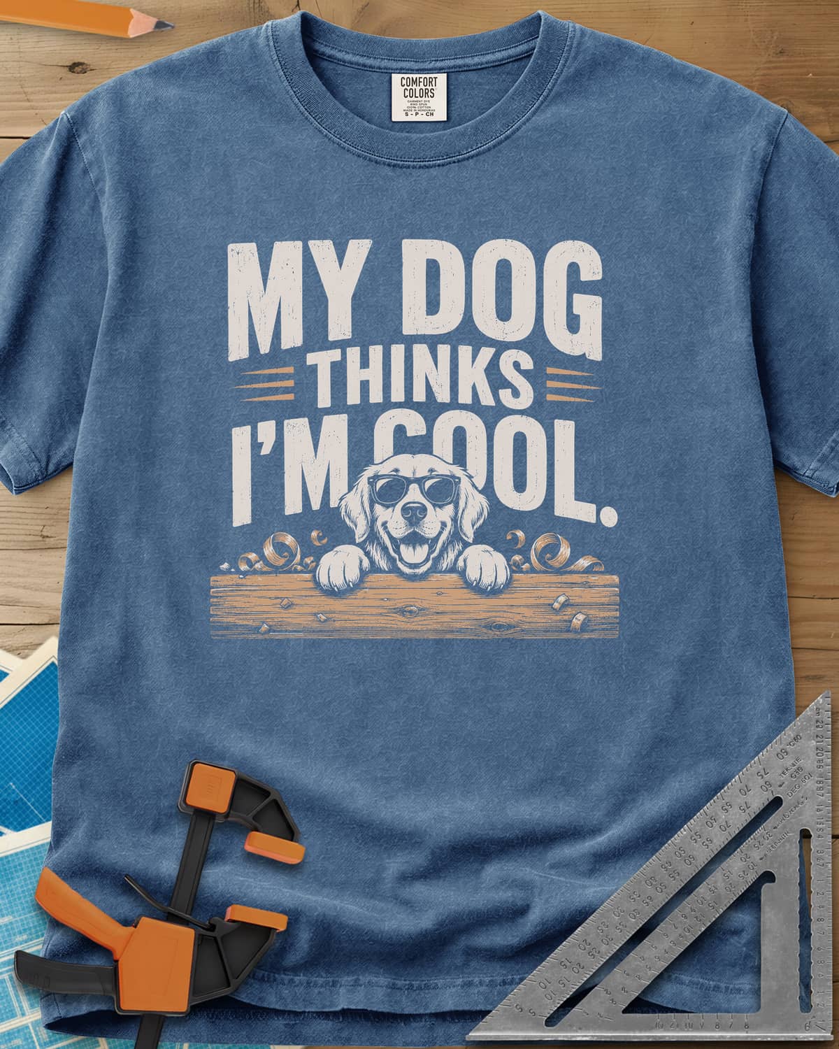 My Dog Thinks I’m Cool heavyweight tee in Blue Jean, a golden retriever in sunglasses peeking over a wood plank