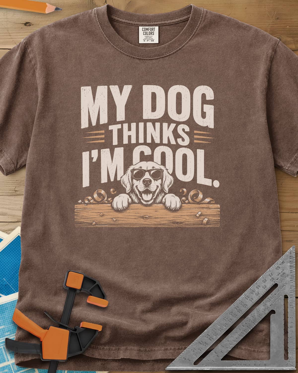 My Dog Thinks I’m Cool heavyweight tee in Espresso, a golden retriever in sunglasses peeking over a wood plank
