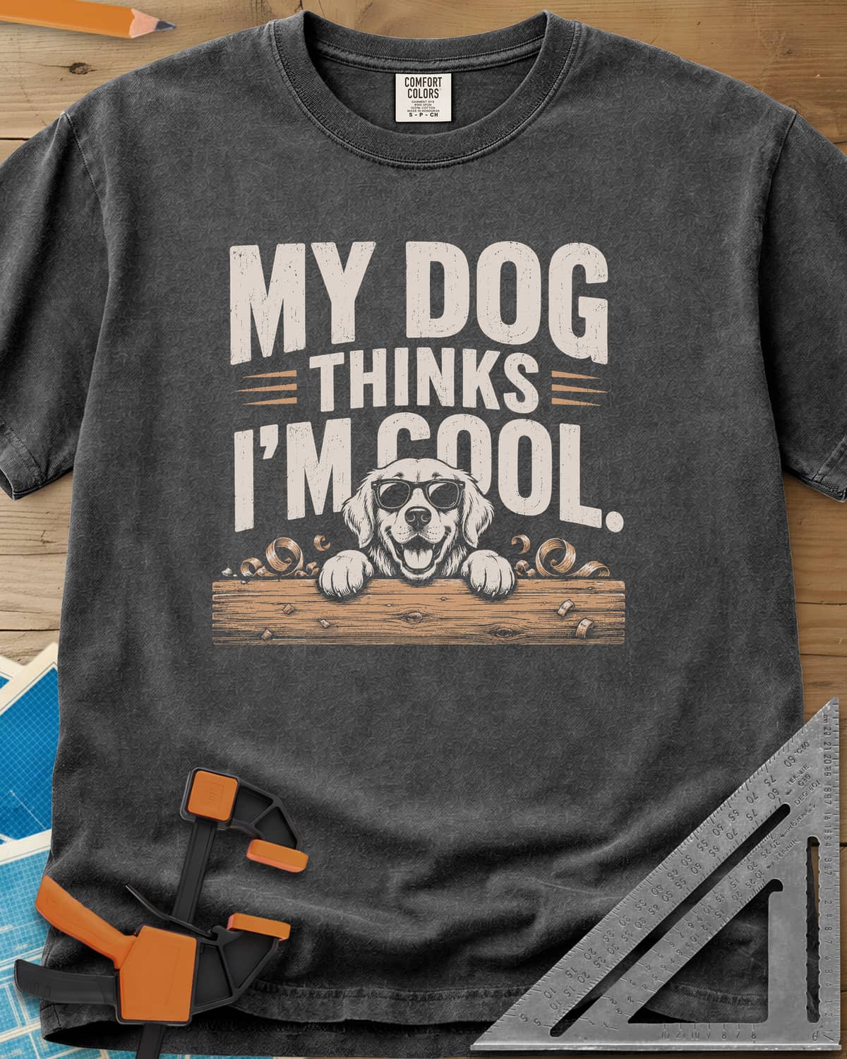 My Dog Thinks I’m Cool heavyweight tee in Pepper, a golden retriever in sunglasses peeking over a wood plank