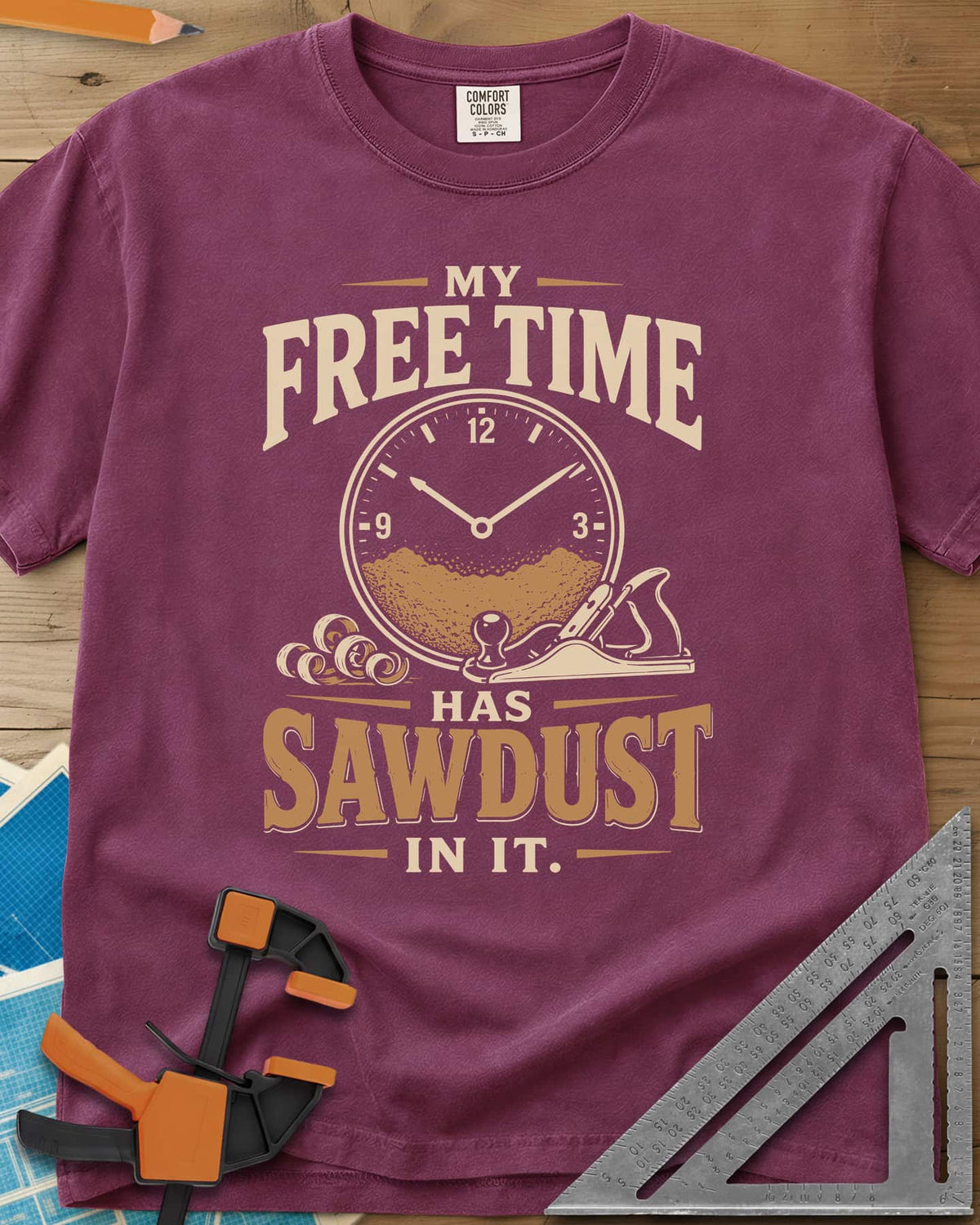 My Free Time Has Sawdust In It heavyweight tee in Berry, a clock face half full of sawdust beside a hand plane and shavings