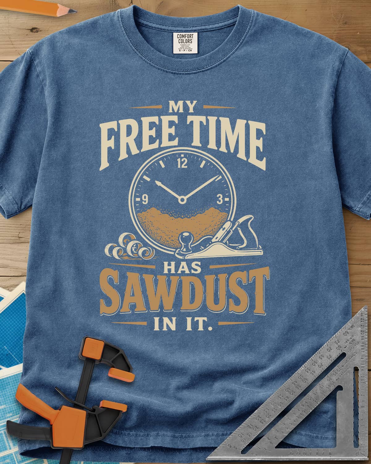 My Free Time Has Sawdust In It heavyweight tee in Blue Jean, a clock face half full of sawdust beside a hand plane and