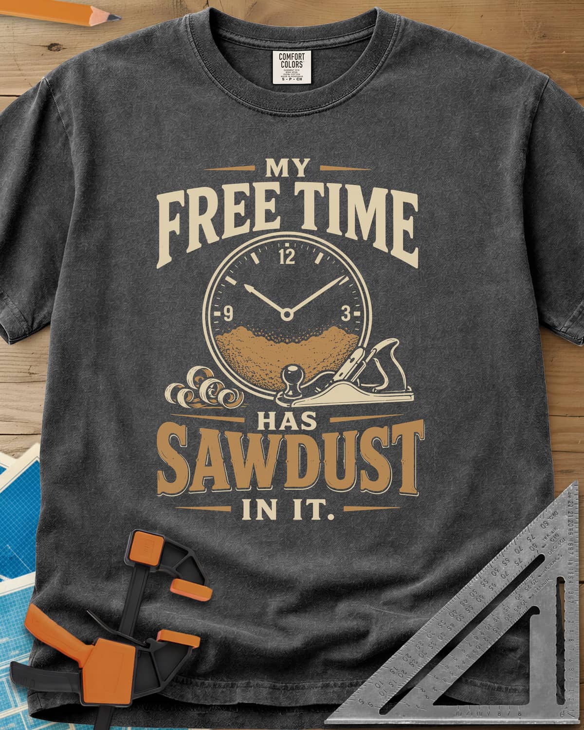 My Free Time Has Sawdust In It heavyweight tee in Pepper, a clock face half full of sawdust beside a hand plane and shavings