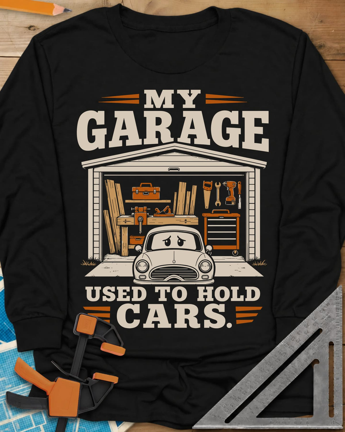 My Garage Used To Hold Cars long sleeve shirt in Black, an open garage full of lumber and tools with a worried car