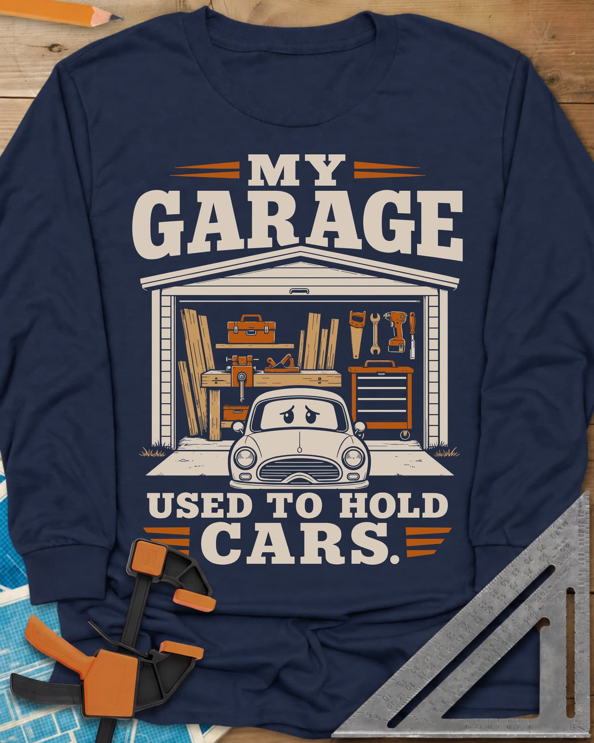 My Garage Used To Hold Cars long sleeve shirt in Navy, an open garage full of lumber and tools with a worried car
