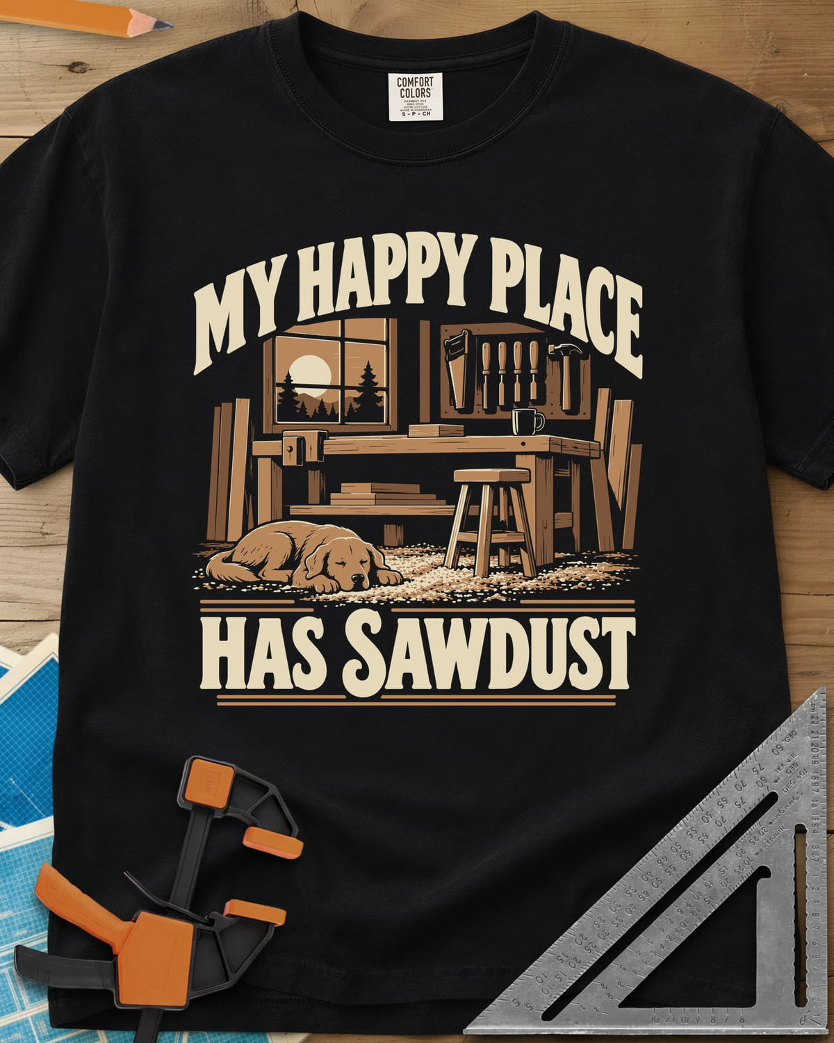 My Happy Place Has Sawdust heavyweight tee in Black, a shop with a workbench, tool wall and a dog asleep on the sawdust
