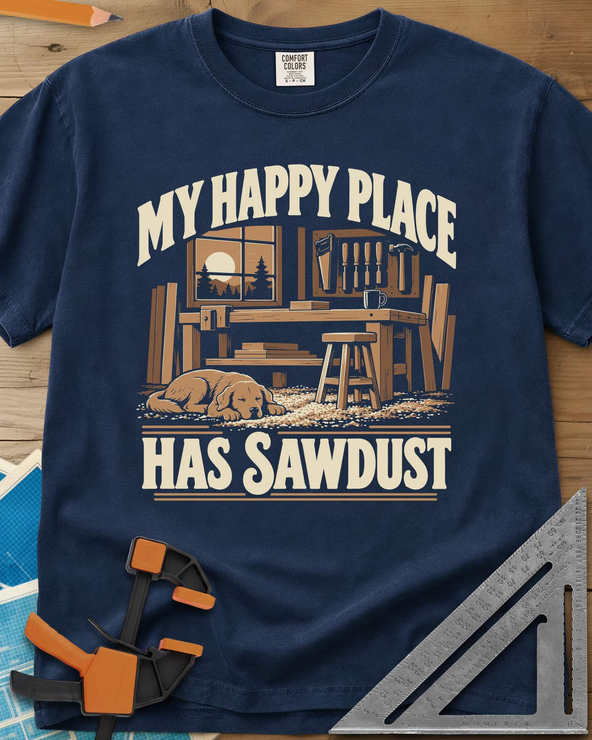 My Happy Place Has Sawdust heavyweight tee in Navy, a shop with a workbench, tool wall and a dog asleep on the sawdust