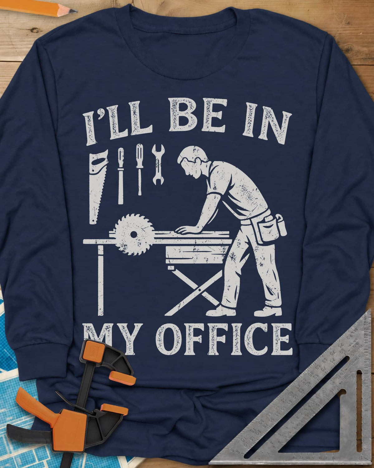 My Office long sleeve shirt in Navy, a woodworker at a table saw with hand tools hung above