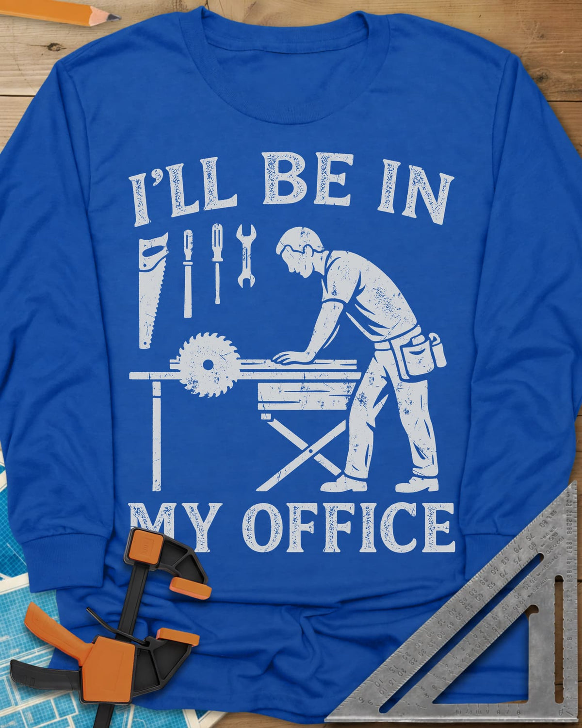 My Office long sleeve shirt in Royal, a woodworker at a table saw with hand tools hung above