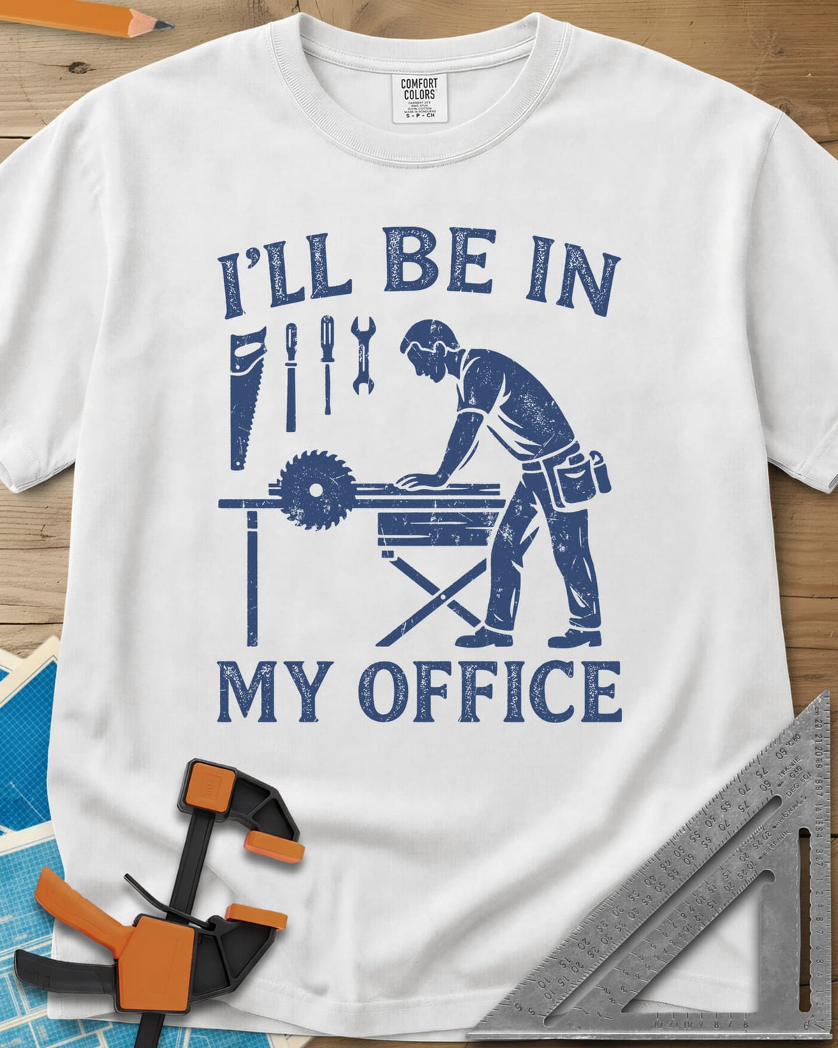 My Office heavyweight tee in White, a woodworker at a table saw with hand tools hung above