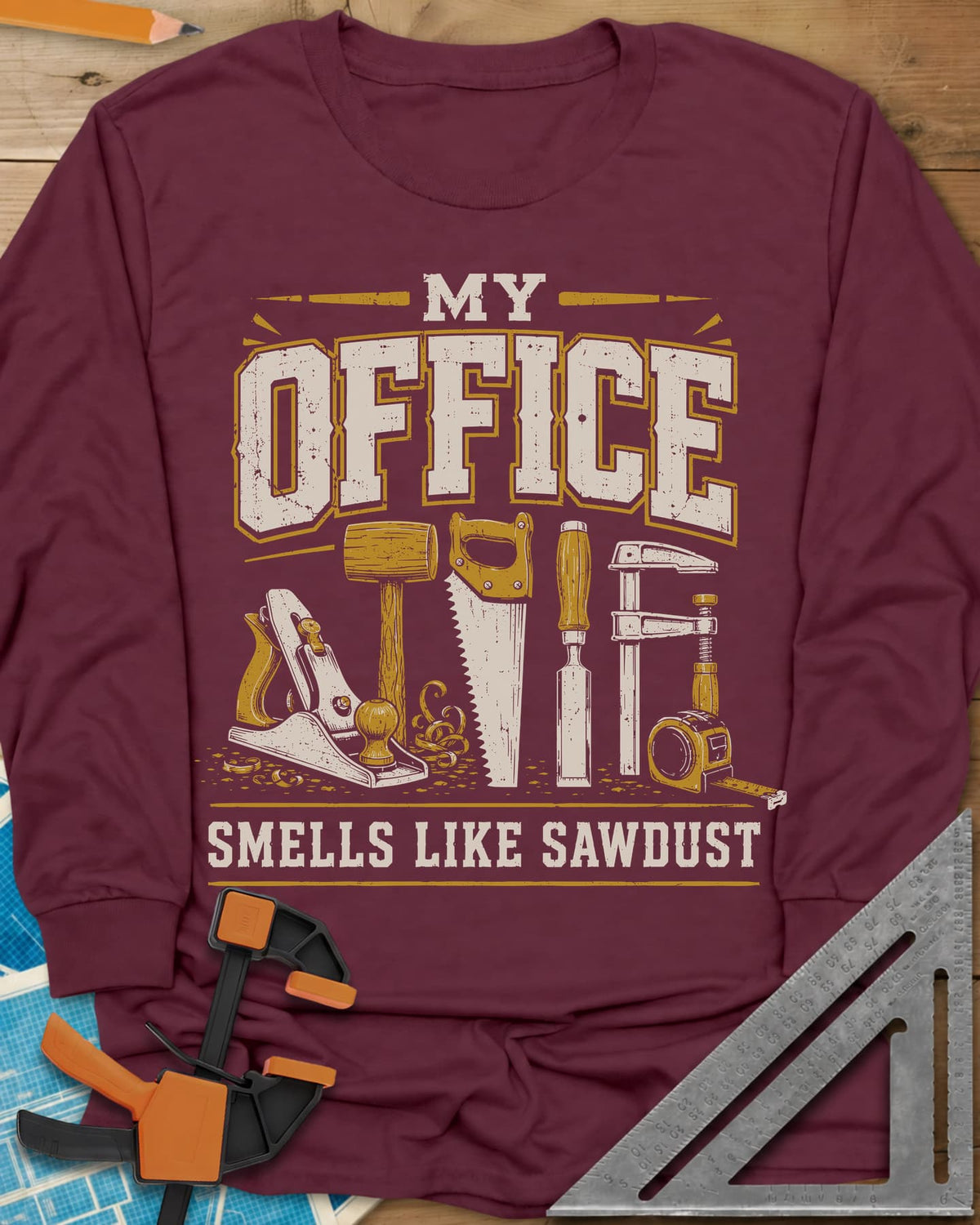 My Office Smells Like Sawdust long sleeve shirt in Maroon, a row of hand tools: plane, mallet, saw, chisel, clamp, tape