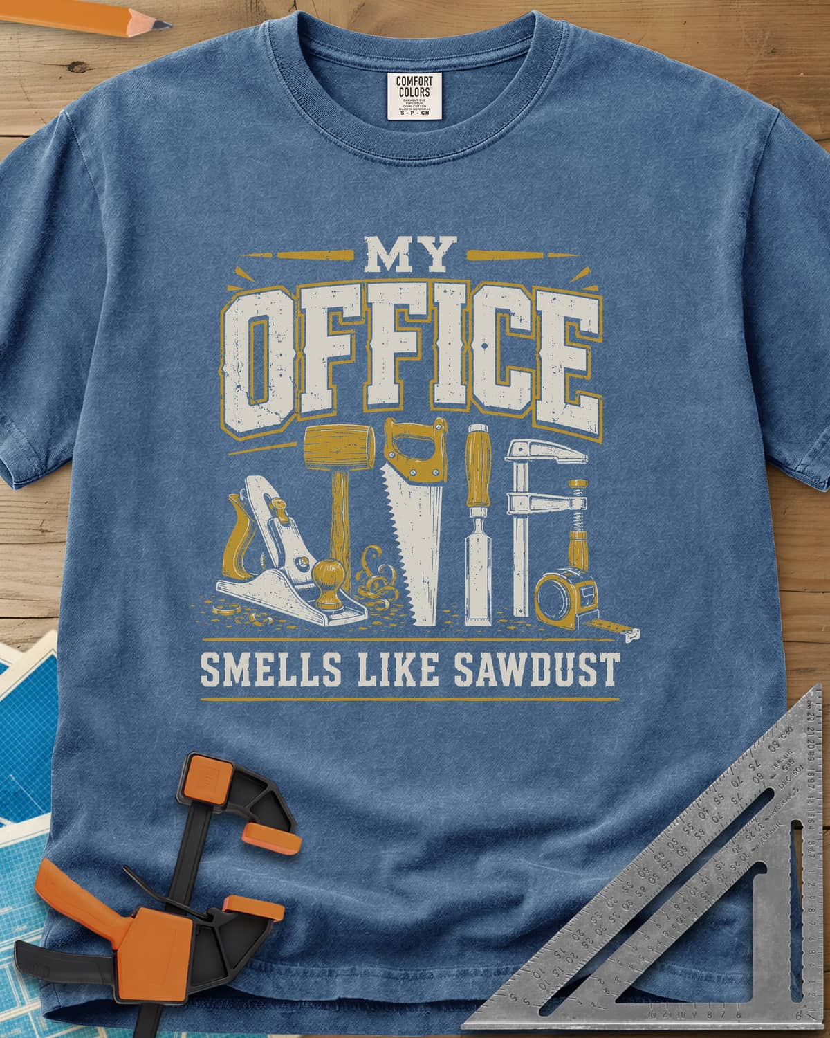 My Office Smells Like Sawdust heavyweight tee in Blue Jean, a row of hand tools: plane, mallet, saw, chisel, clamp, tape