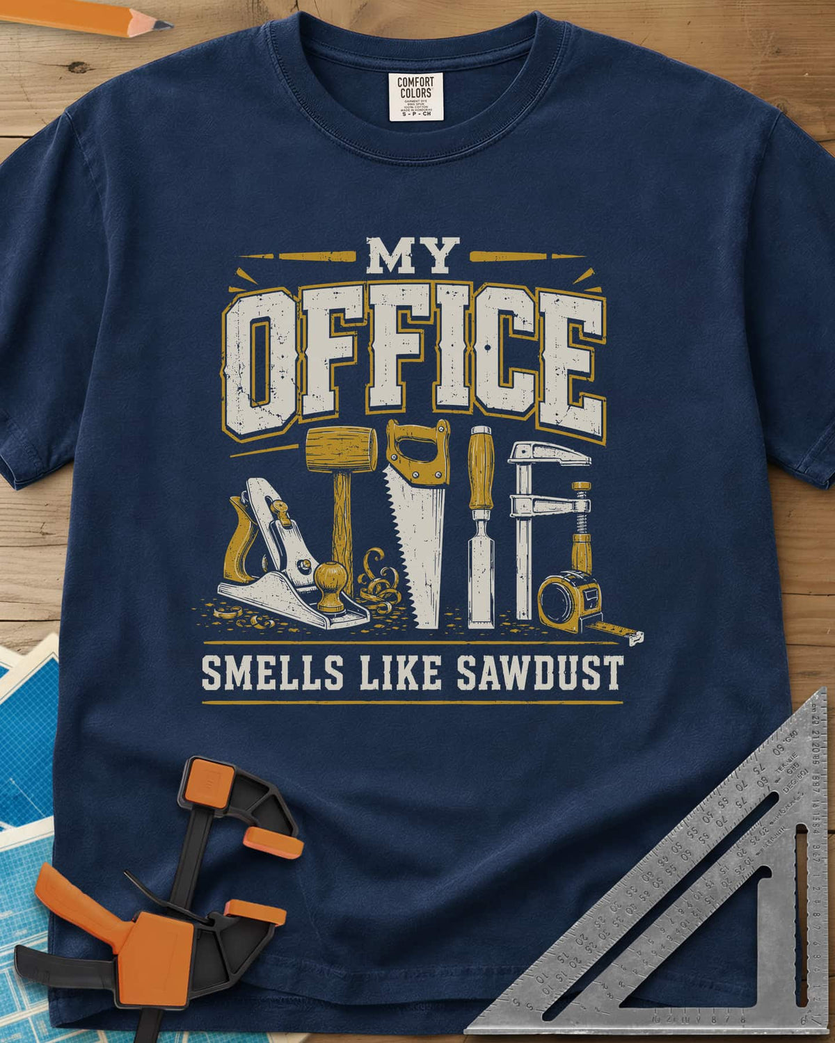 My Office Smells Like Sawdust heavyweight tee in Navy, a row of hand tools: plane, mallet, saw, chisel, clamp, tape
