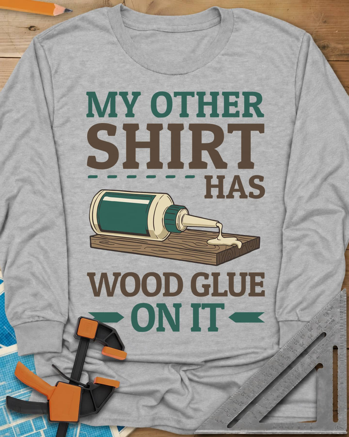 My Other Shirt Has Wood Glue On It long sleeve shirt in Sport Grey, a tipped-over wood glue bottle dripping onto a board