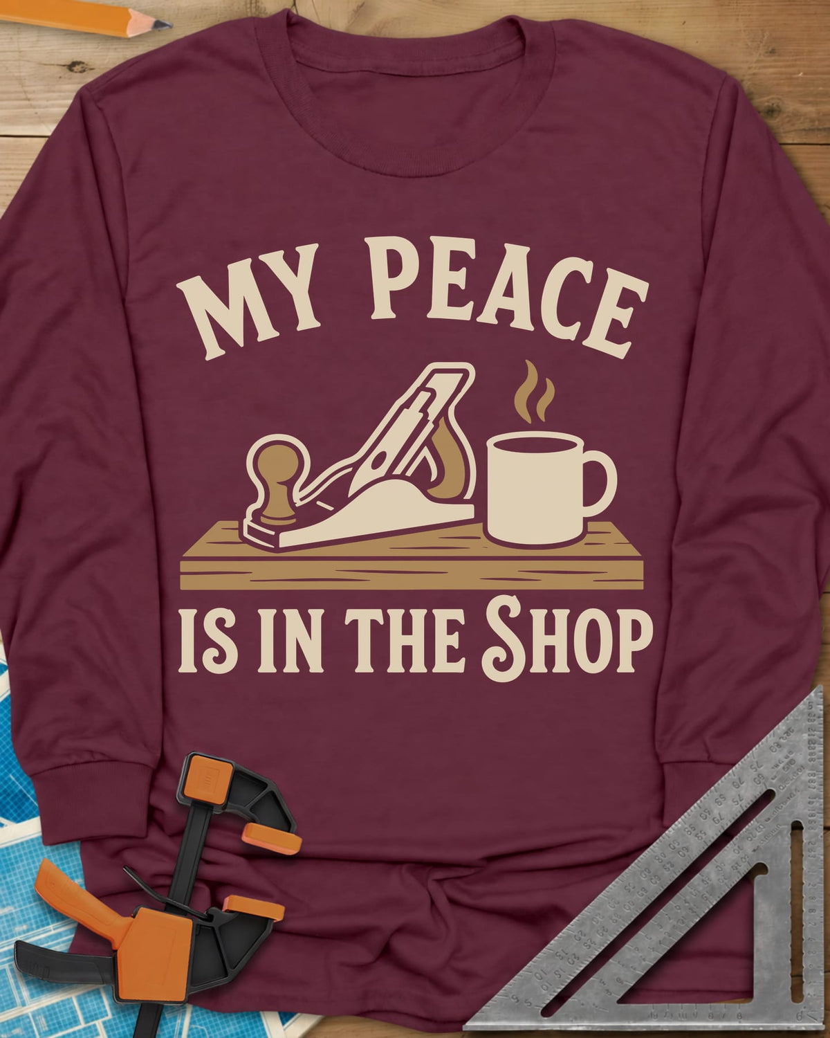 My Peace Is In The Shop long sleeve shirt in Maroon, a hand plane on a plank beside a steaming coffee mug
