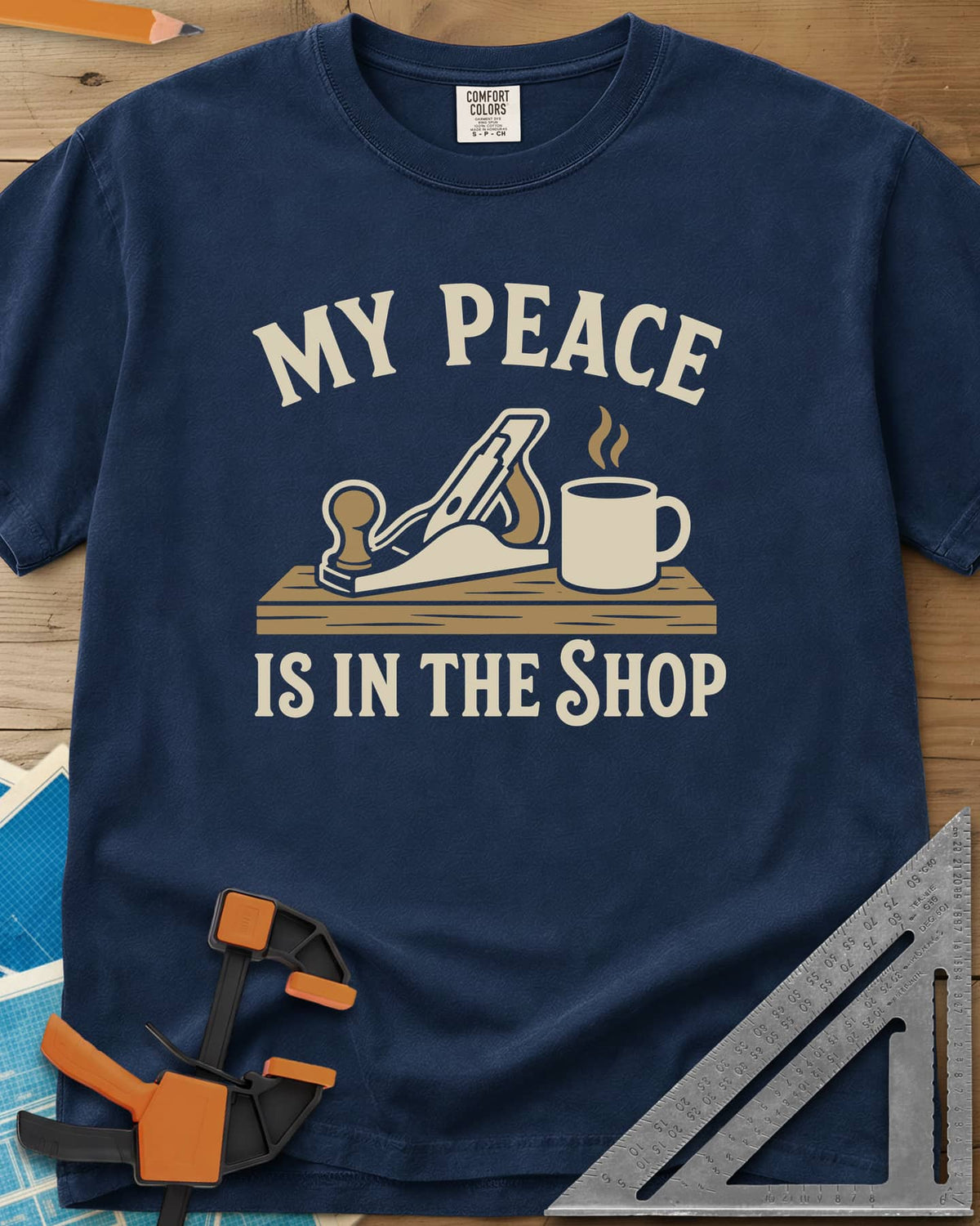 My Peace Is In The Shop heavyweight tee in Navy, a hand plane on a plank beside a steaming coffee mug