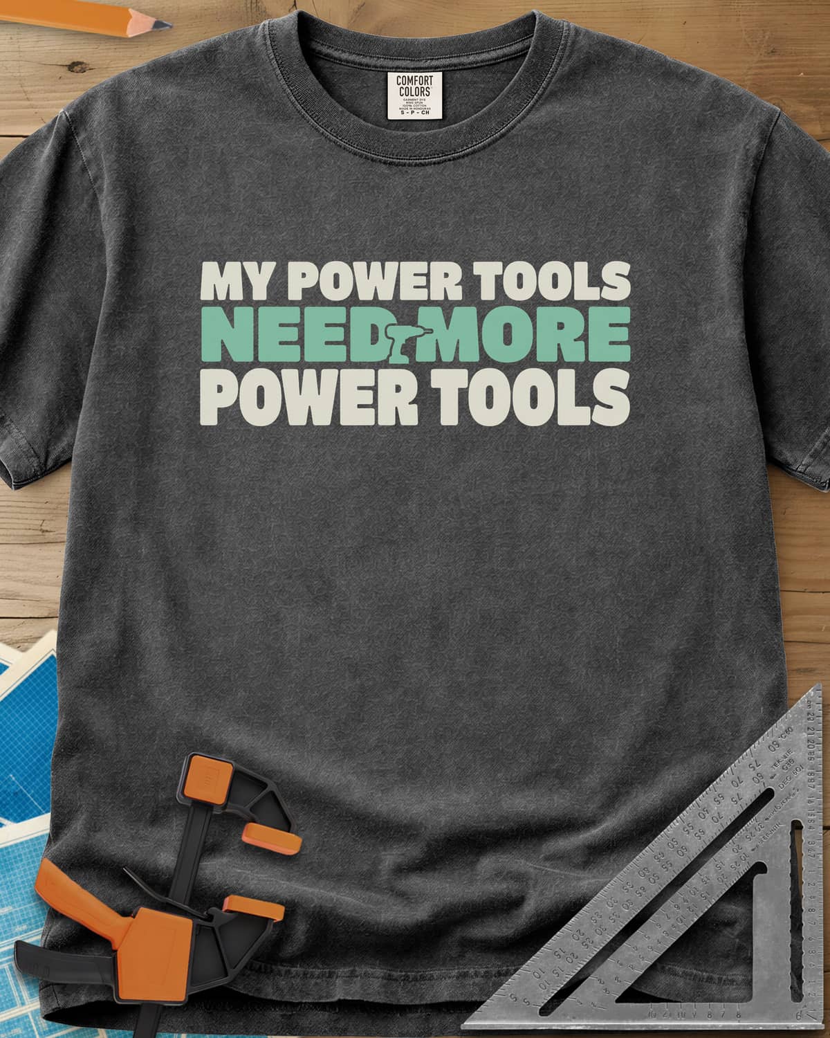 My Power Tools Need More Power Tools heavyweight tee in Pepper, bold three-line type with a tiny cordless drill in the middle