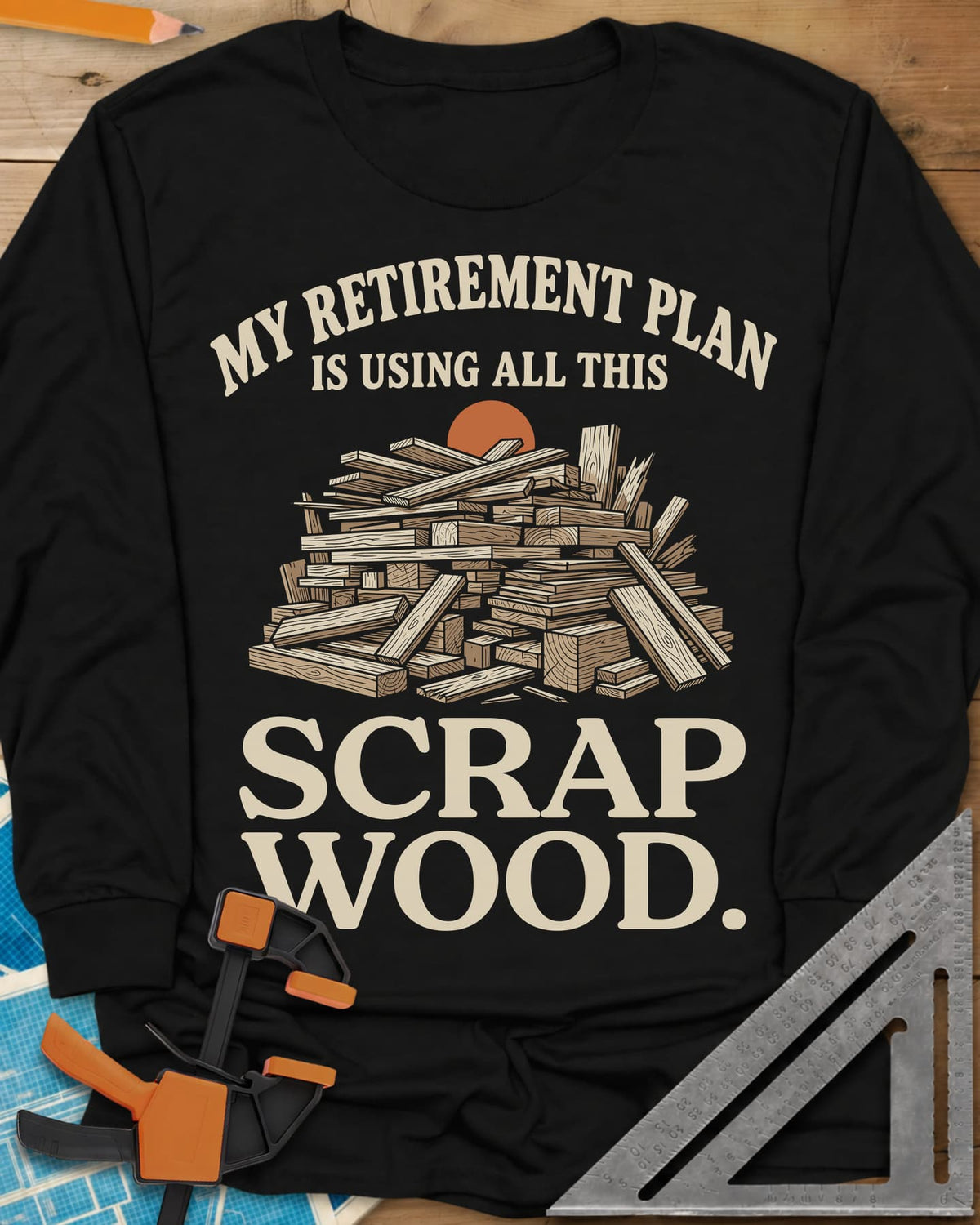 My Retirement Plan Scrap Wood long sleeve shirt in Black, a heaped pile of scrap boards in front of a setting sun