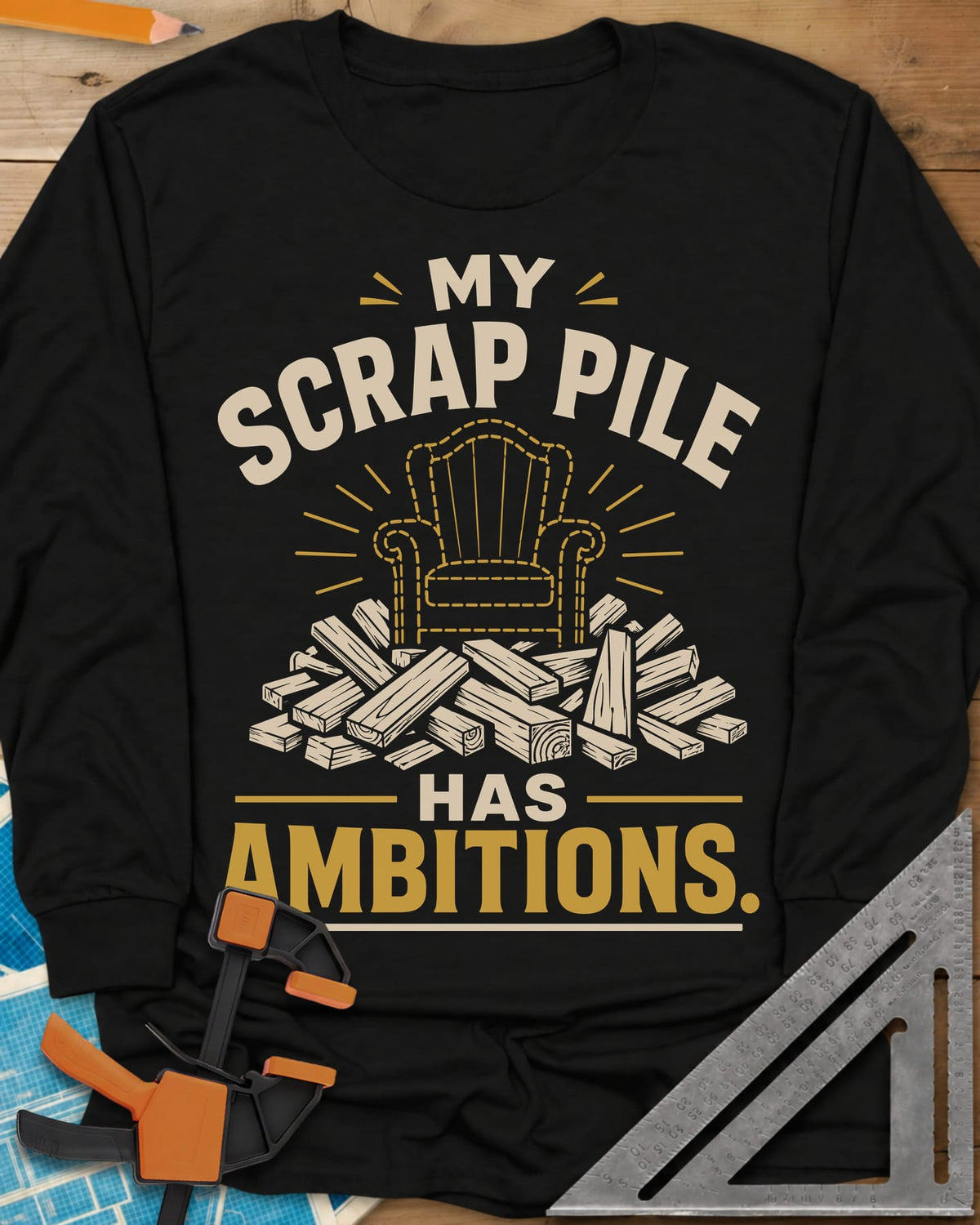 My Scrap Pile Has Ambitions long sleeve shirt in Black, a dotted gold armchair outline rising from a pile of wood offcuts